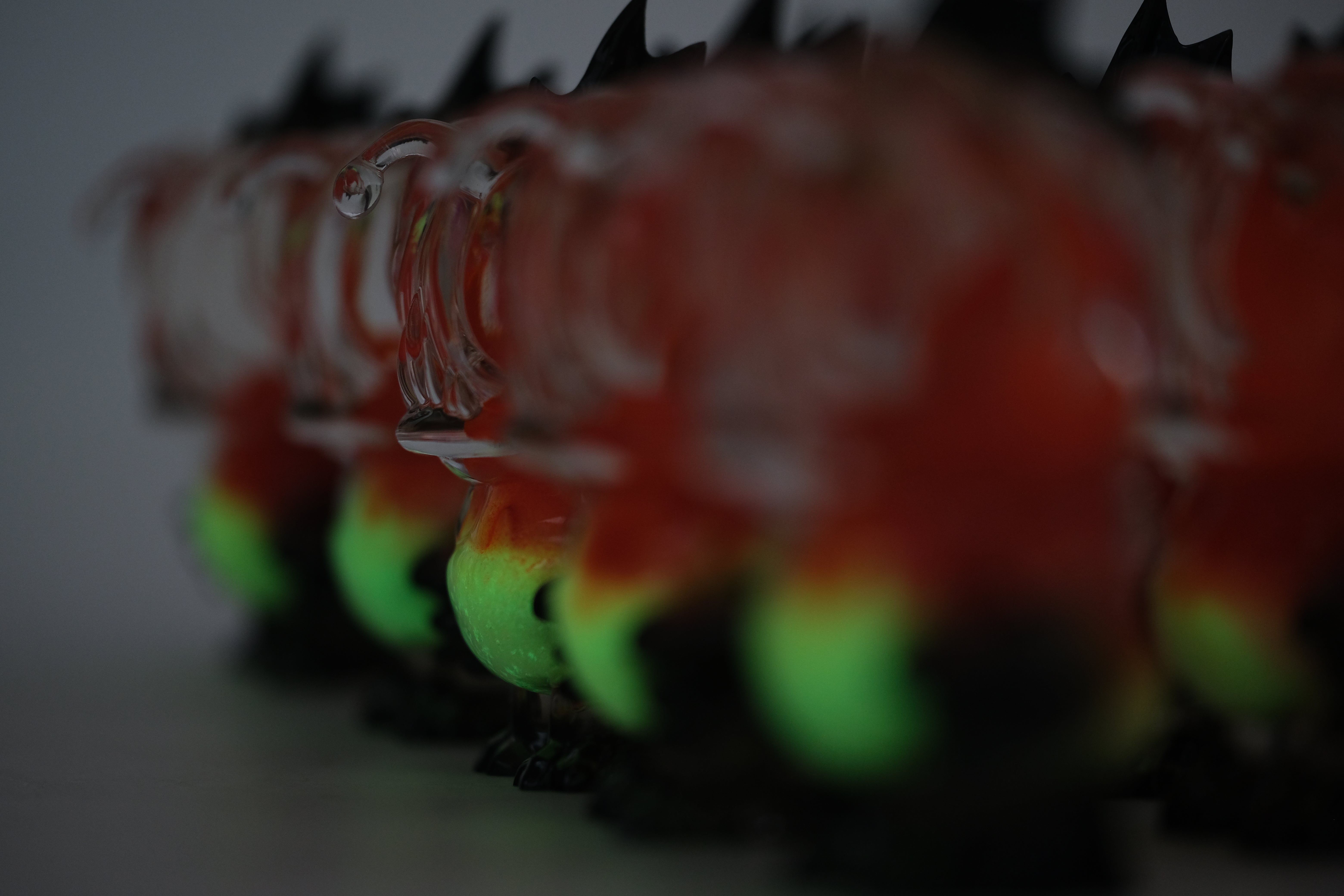 Angie Evo - Chicago Fire by 5th Turtle, a 3.5 hand-blown glass figurine, features a red/orange top, glowing green belly, and black accents.