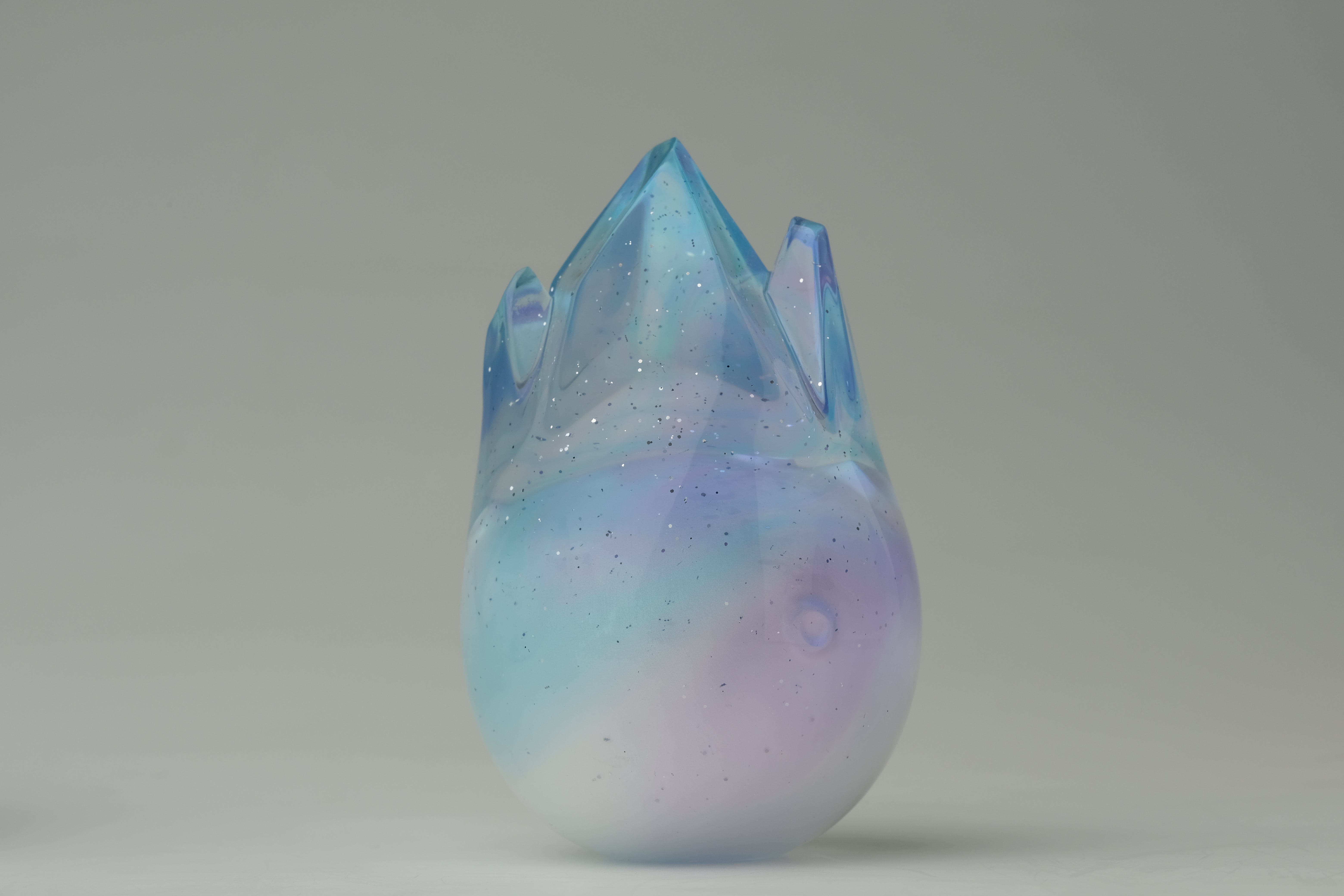 Aurora Cosmite by Yutoos, an iridescent 3.5 resin vessel with crown-like points, featuring unique pastel tones and flecks, limited edition of 50.