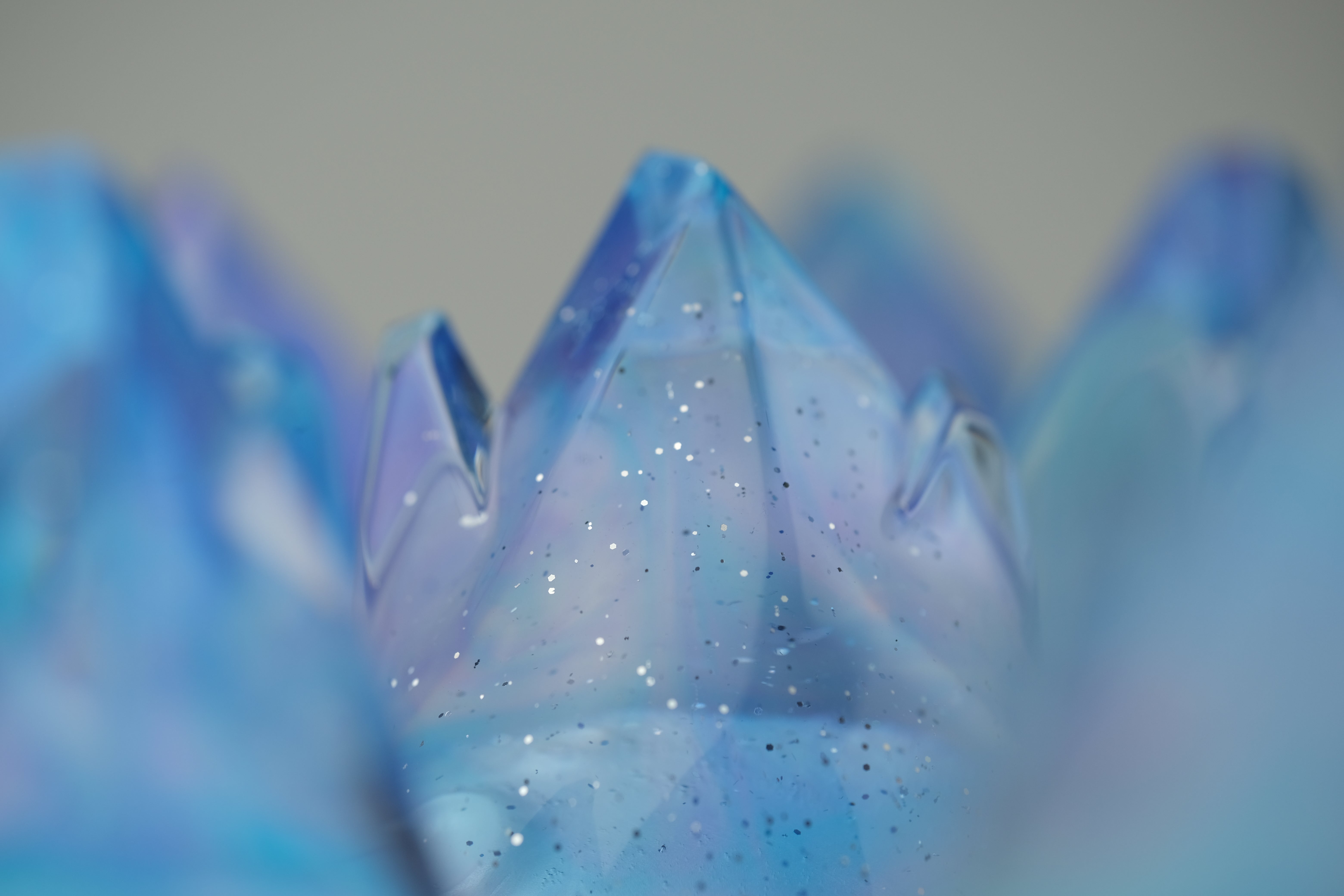 Aurora Cosmite by Yutoos, a 3.5 blue resin sculpture with faceted peaks and silvery sparkles, resembling stylized crystals. Limited edition of 50, each unique.