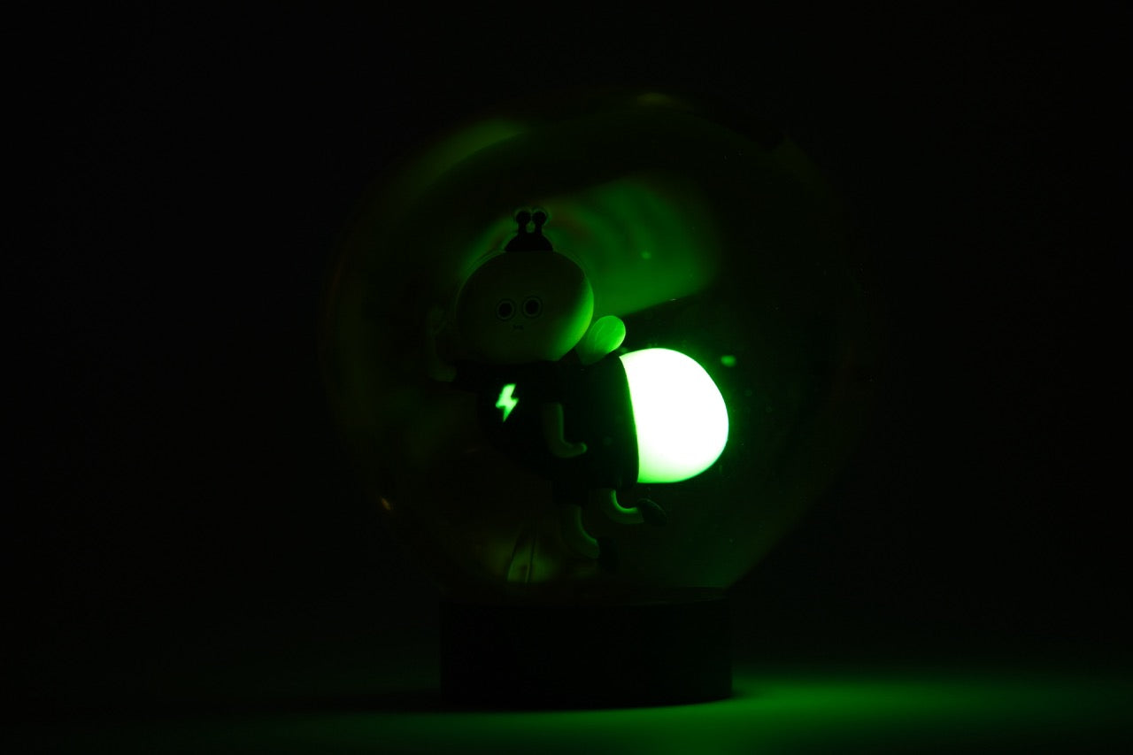Lightning Bug by Sad Salesman, a 3 resin figurine in a globe, features a cartoonish character with LED-lit green orb for moody ambiance.