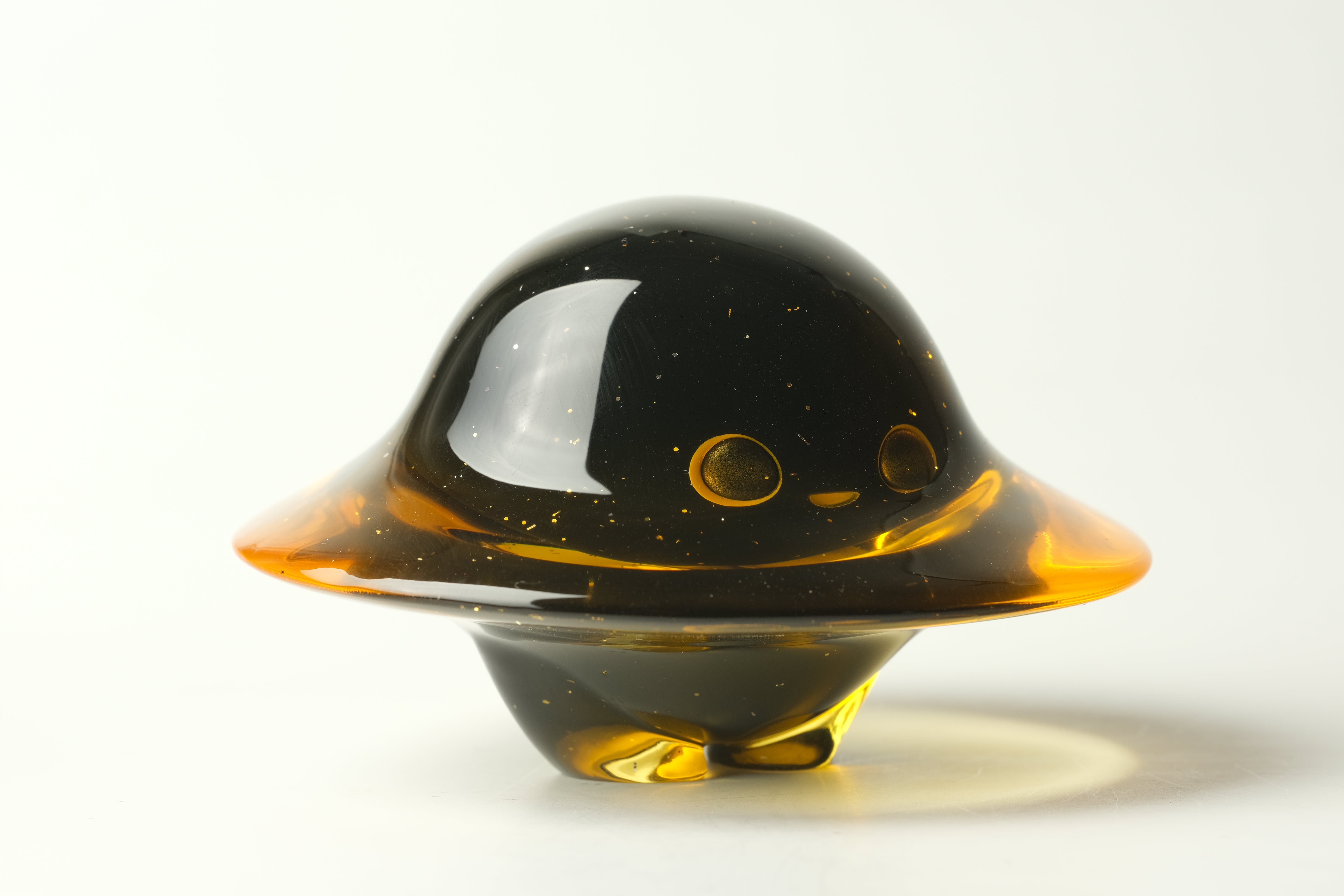 Darkmite by Yutoos: A 3.5 amber-tinted resin art toy, UFO-shaped with glitter, featuring a cute alien face under a dome. Limited edition of 50.