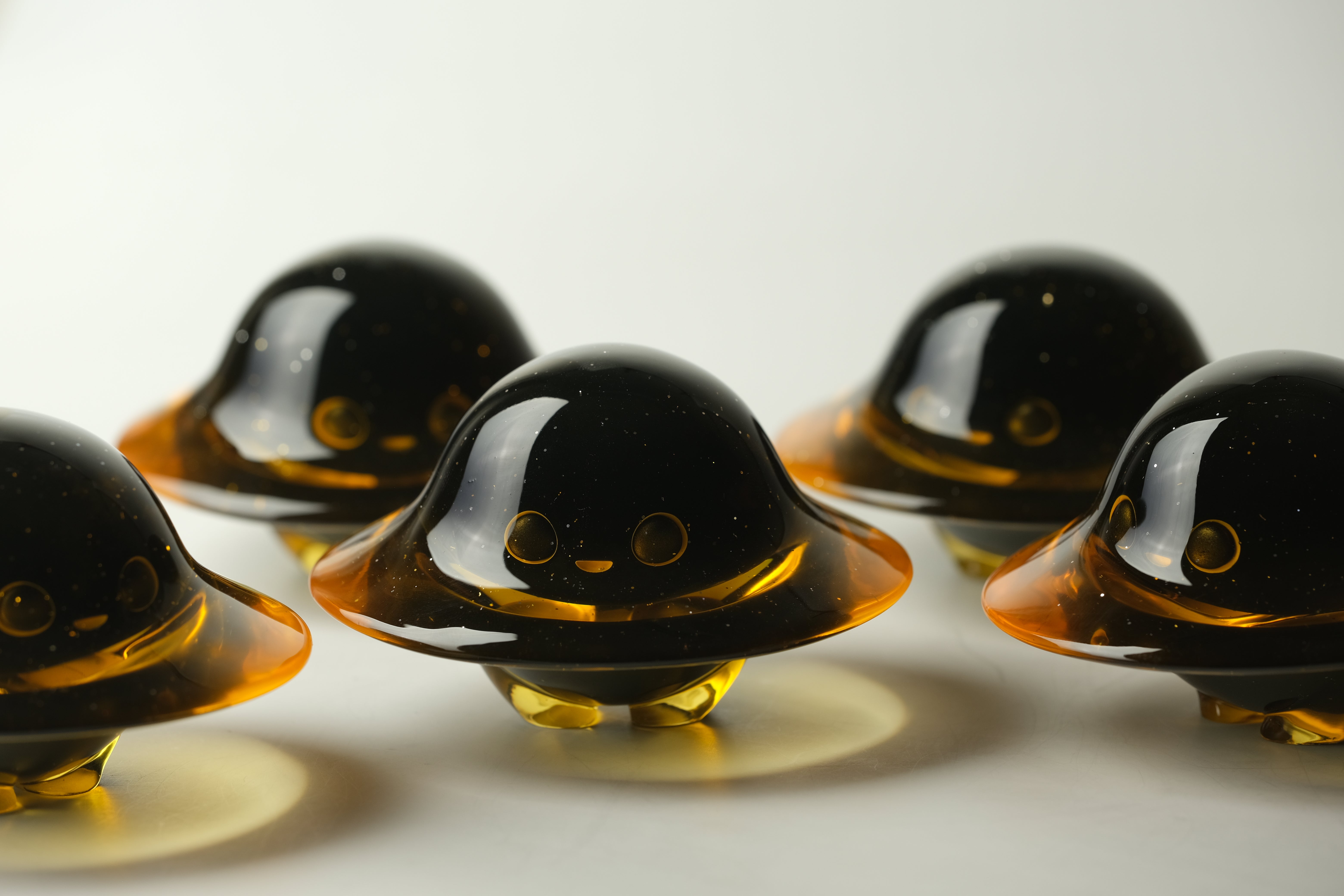 Darkmite by Yutoos: Five small, translucent resin figurines, each with a dome top and smiling face, part of a unique limited edition of 50.