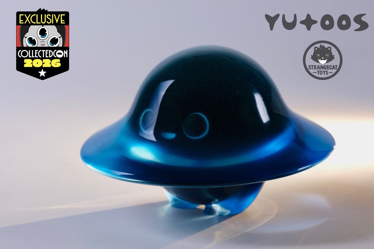 Glow in the Darkmite! by Yutoos, a translucent, glossy-blue UFO-shaped designer toy with a cat-face motif, exclusive for CollectedCon 2026.