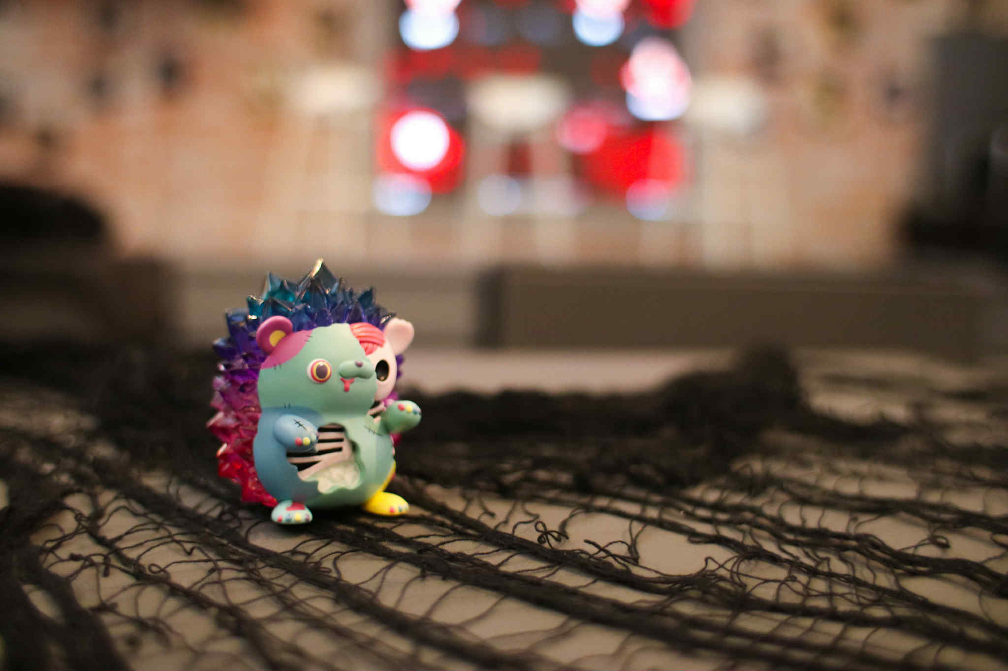 Spooky Zombie Hogkey by Tangent, a colorful vinyl toy with jewel-tone spikes and painted ribs, available for preorder, sitting on black fabric.