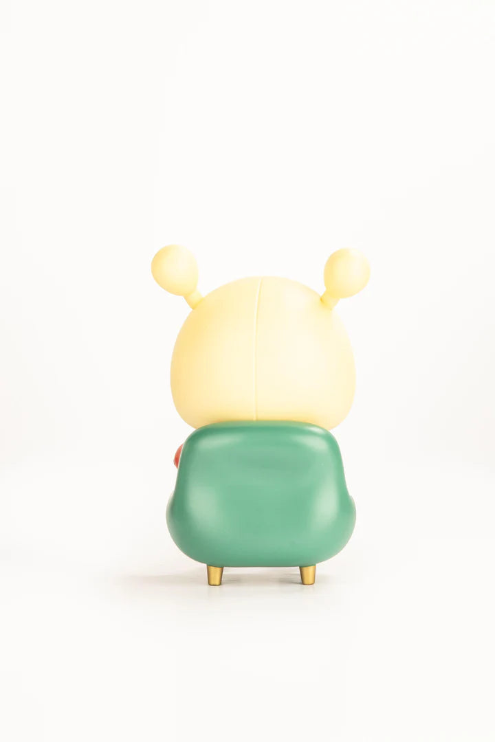 Napa Series One vinyl figure with yellow head and antennae, seated in a modern green chair with golden legs, capturing the essence of Strangecat Toys' art collectibles.