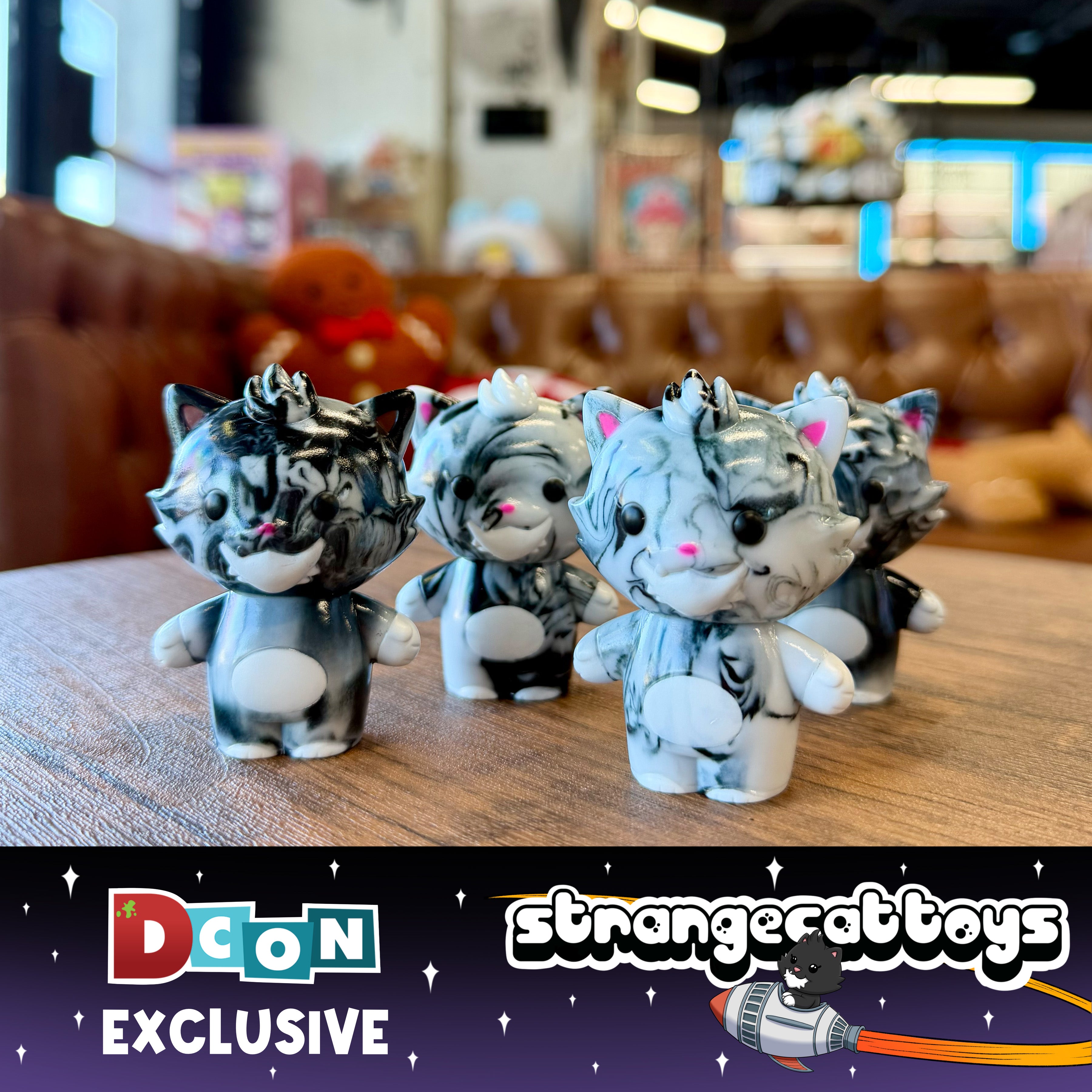 Grandpa Sofubi Marbled Black & White: Set of five 10cm vinyl cat figurines with pink noses, posed on a tabletop, featuring an exclusive “DCon” banner.