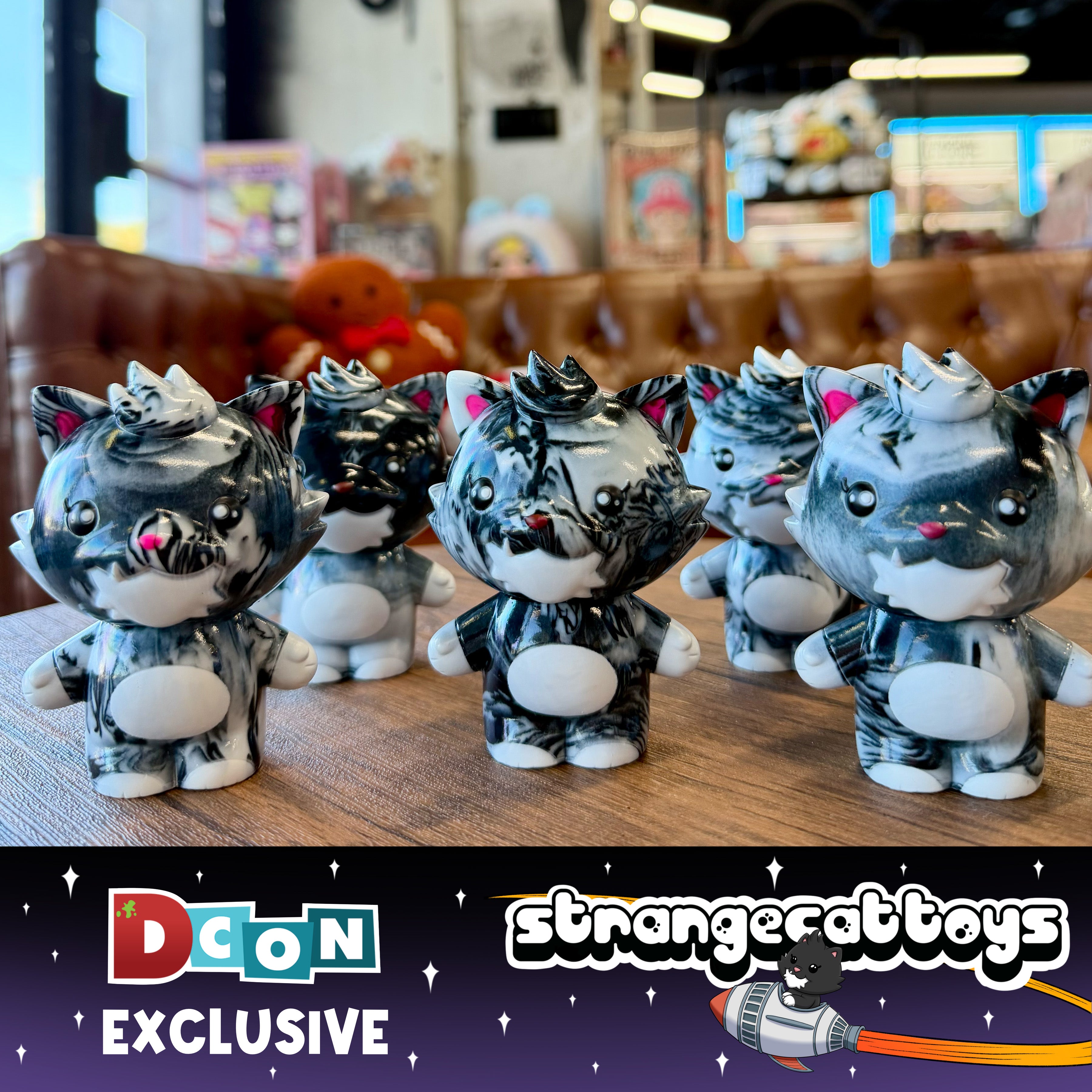 Five marble-black-and-white Grandpa Sofubi vinyl cat figures on a wooden tabletop, exclusive to Strangecat Toys, sculpted by P.P.PUDDING.