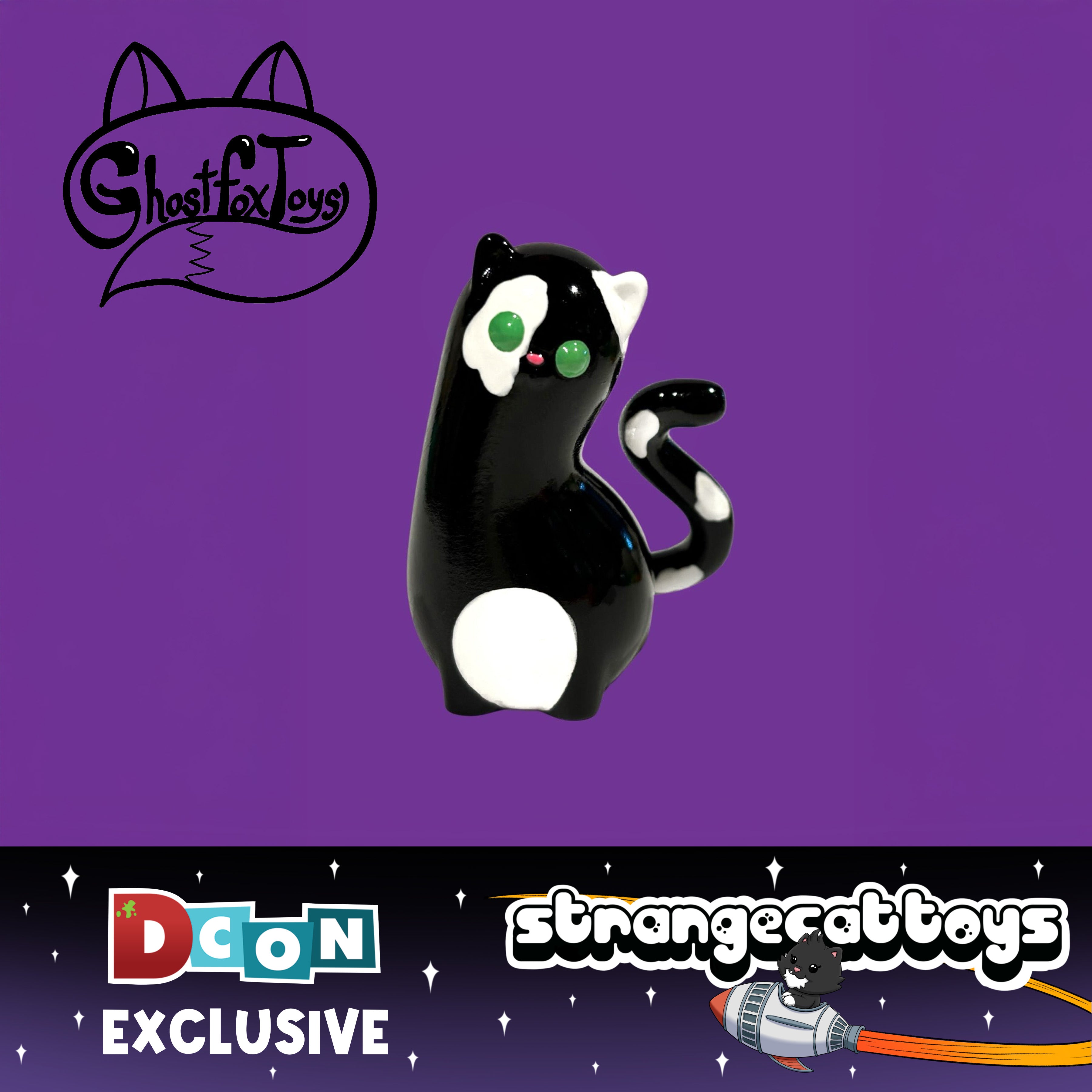 Spencer by Ghost Fox Toys: A DesignerCon-exclusive black-and-white cat figurine with bright green eyes, featuring logos from Ghost Fox Toys and Strange Cat Toys.