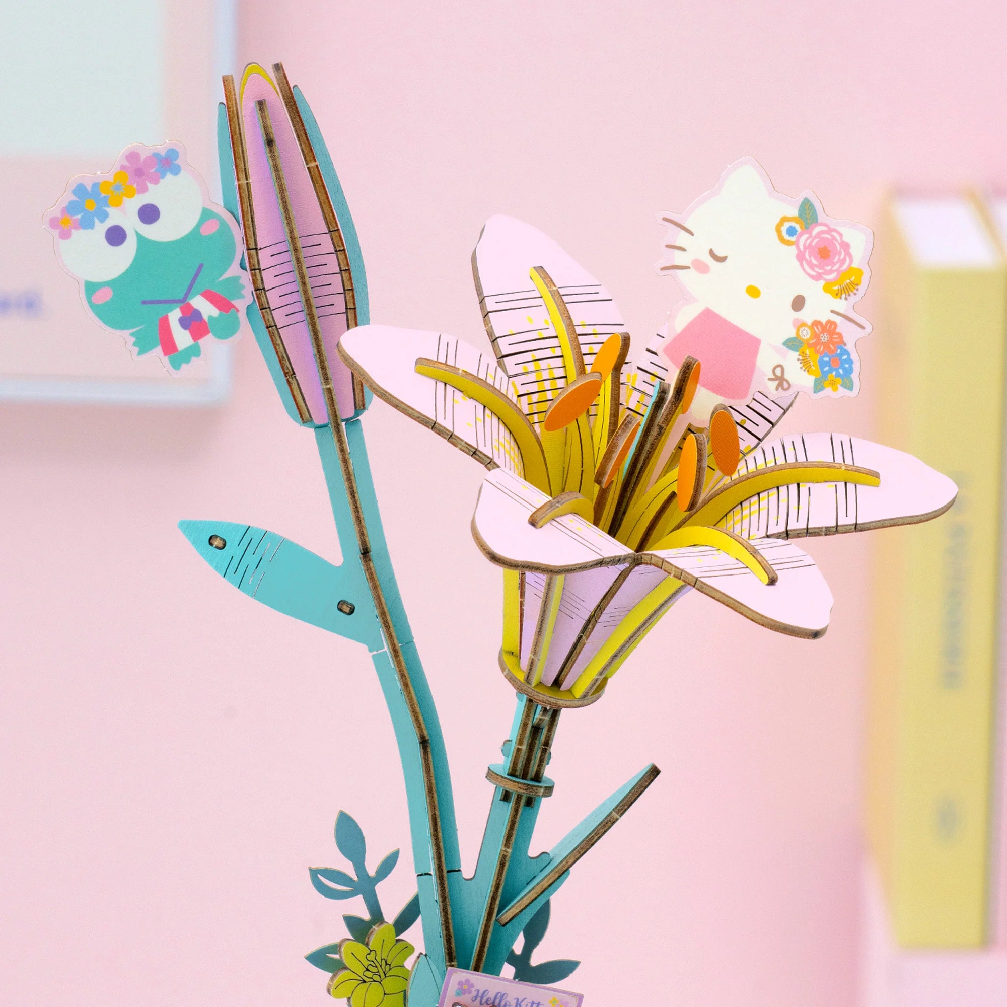Hello Kitty® and Friends DIY puzzle kit features a 3D wooden lily with Keroppi and Hello Kitty paper cut-outs, ideal for craft enthusiasts.
