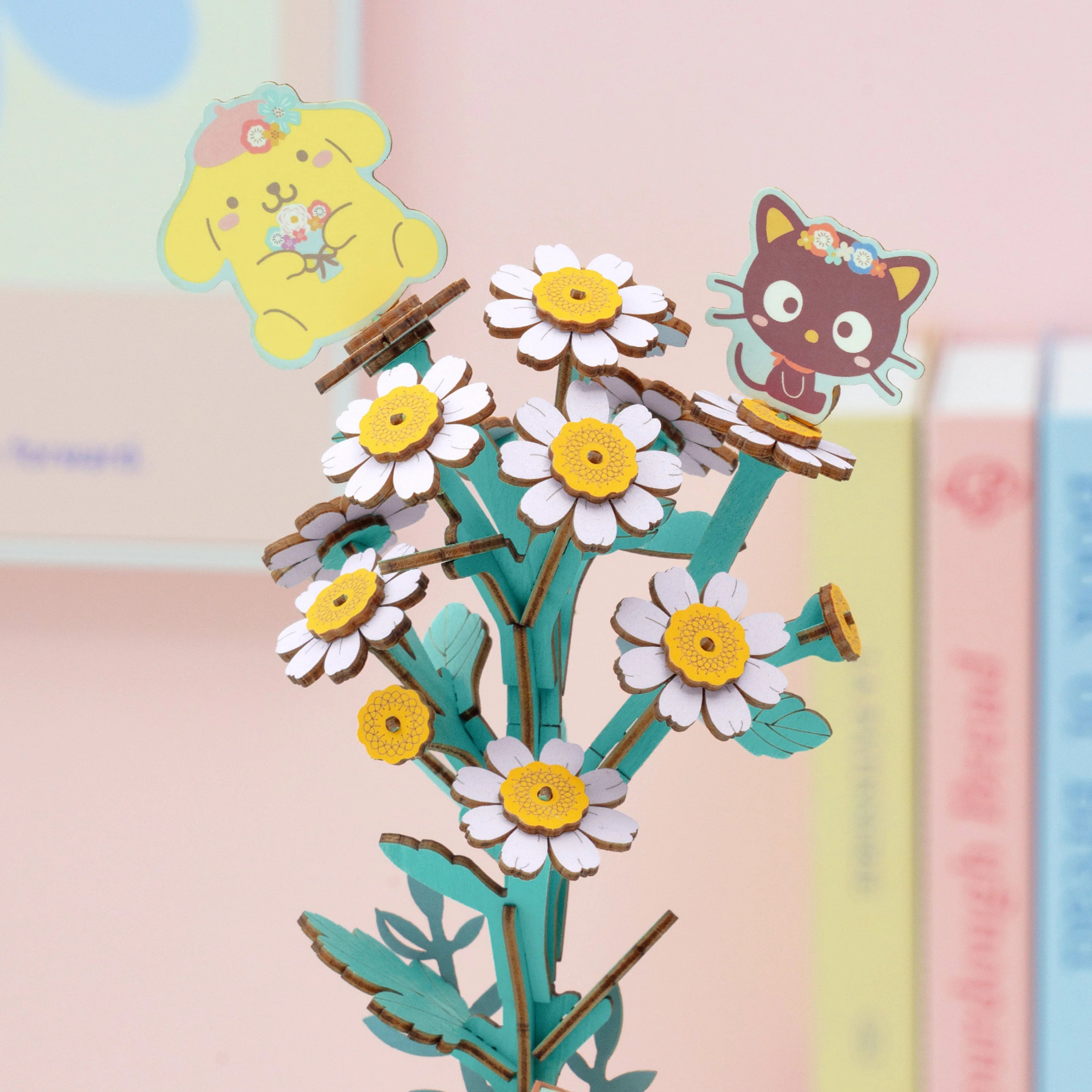 Hello Kitty® and Friends Pompompurin & Chococat Chamomile DIY puzzle with daisies, featuring yellow puppy and brown cat toppers; a charming craft from Strangecat Toys.
