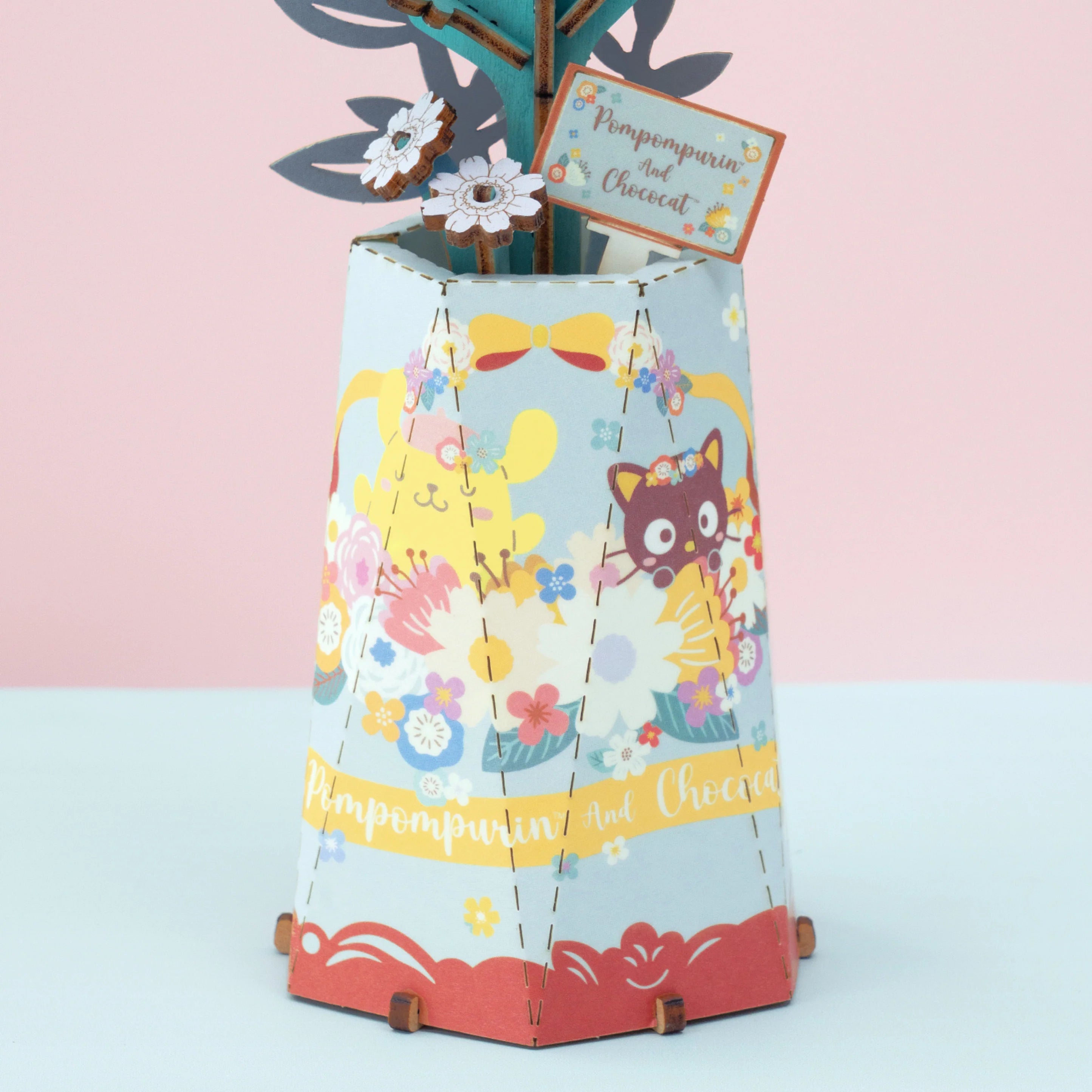 DIY paper vase featuring Sanrio's Pompompurin and Chococat with flowers; a 99-piece craft kit, perfect for fans and creative projects.