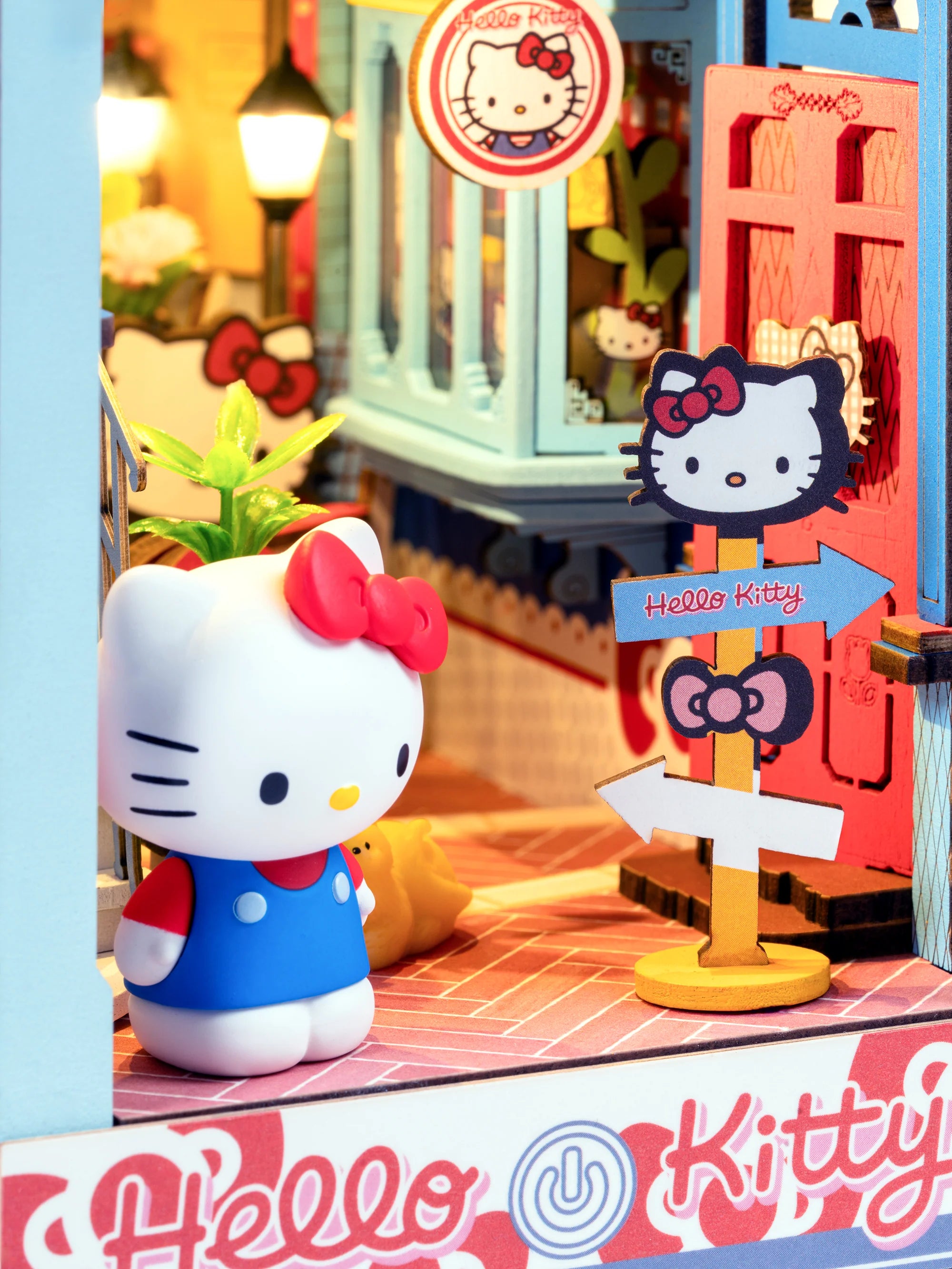 Hello Kitty® Town Square Booknook features a Hello Kitty figurine and signpost, nestled in a charming mini street scene with cafes and shops.