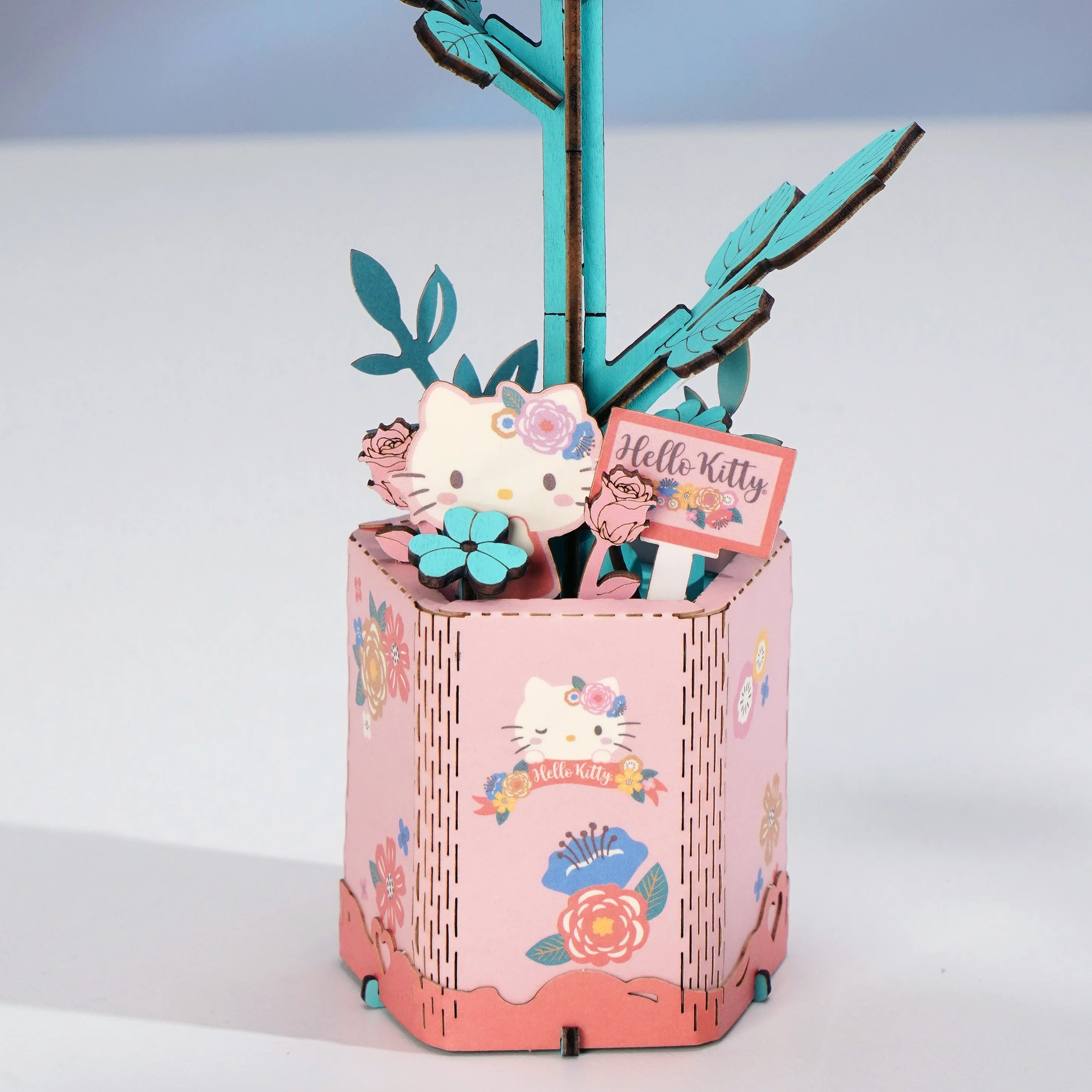 Hello Kitty Pink Rose pen holder with floral graphics, teal branches, and 3D Hello Kitty elements, perfect for craft enthusiasts and decorative display.