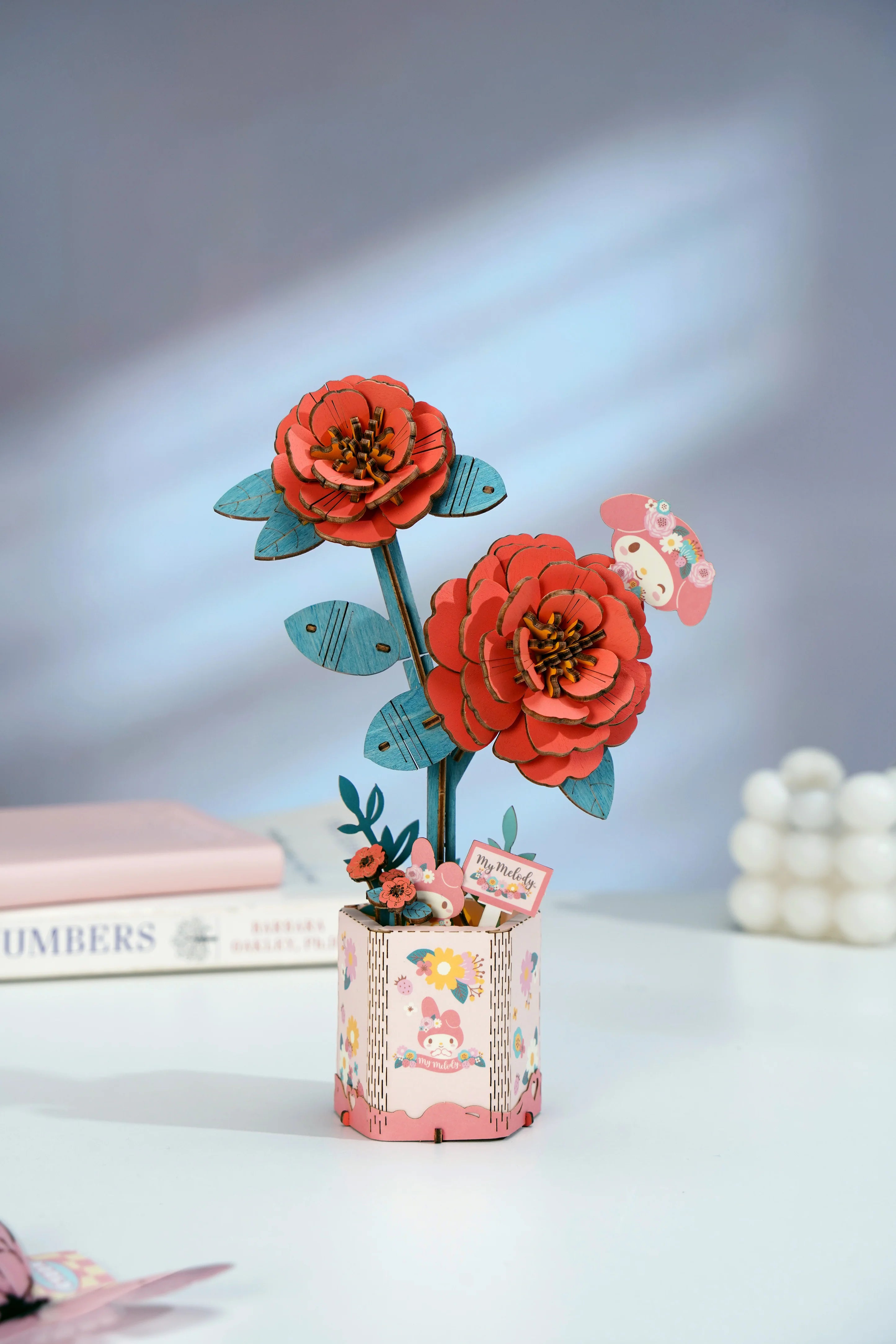 Hello Kitty® and Friends My Melody Red Camellia 3D wooden puzzle, featuring laser-cut flowers in a pastel-pink pot, designed for creative assembly.