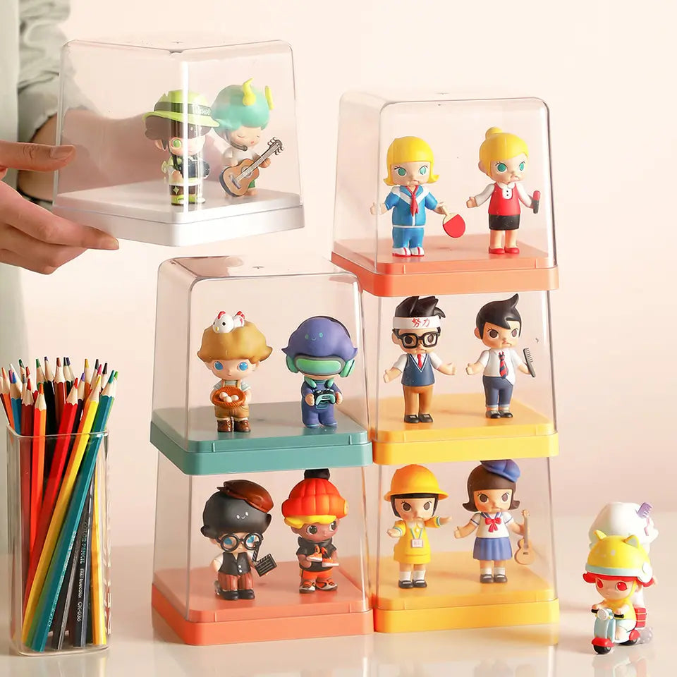 A group of small toy figurines in a clear acrylic display case from Strangecat Toys.