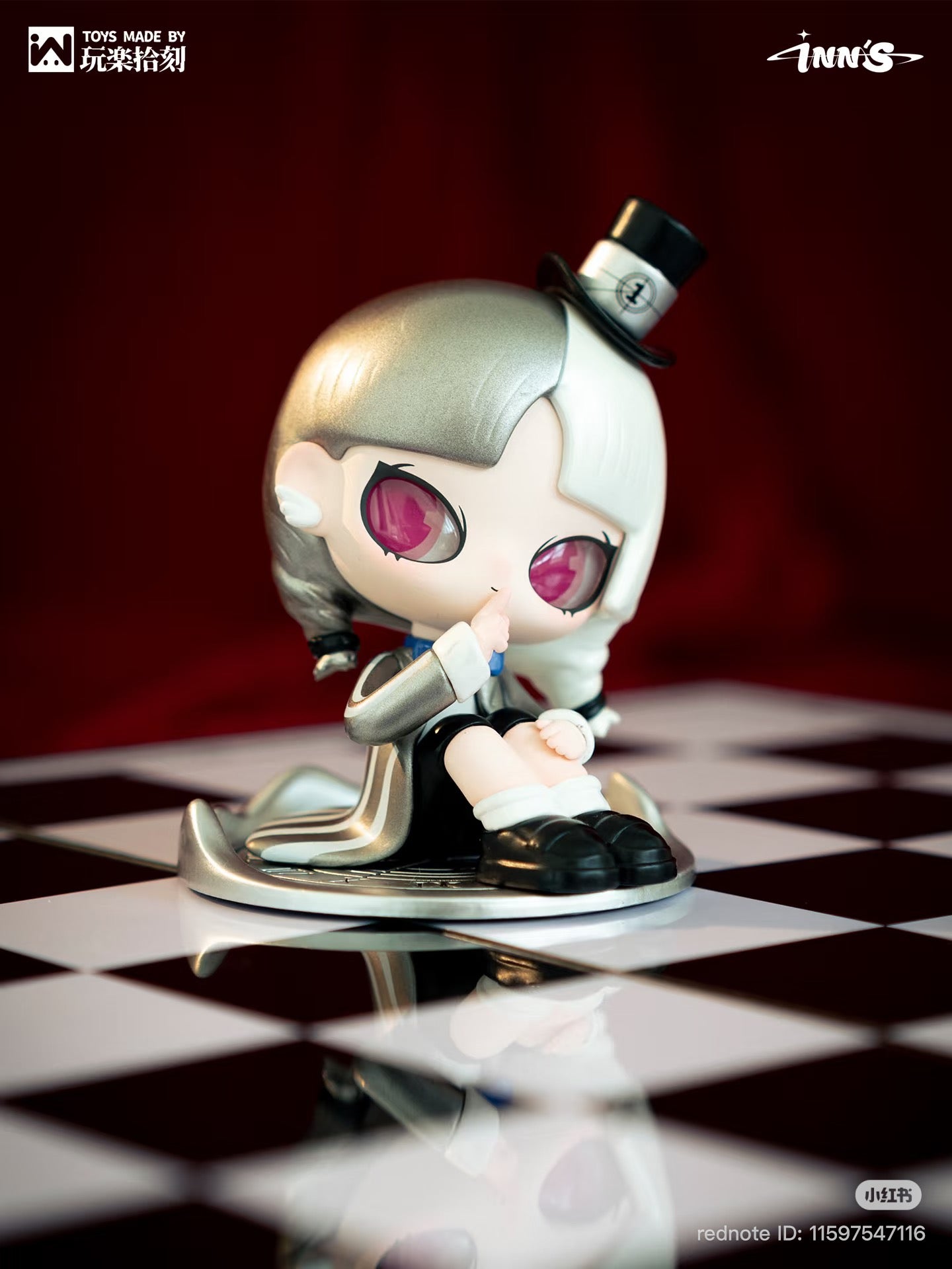 Chibi-style vinyl figure from NN – I Heard It Series Blind Box, posed thoughtfully on a checkerboard surface, featuring pink eyes and distinctive half-silver/half-white hair.