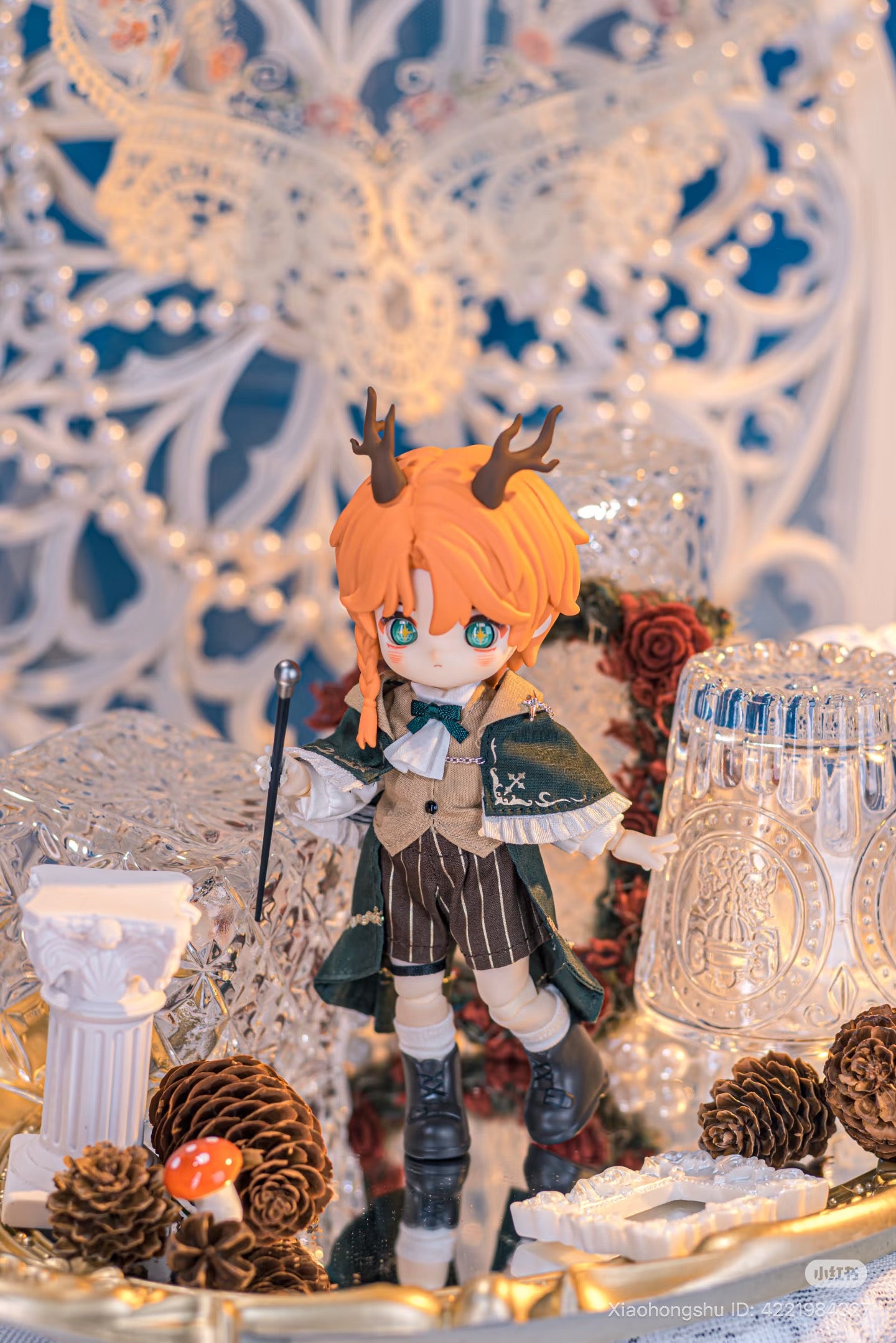 Chibi-style NAGI: The Phantom Record Series Figure with orange hair, antlers, Victorian outfit, and wand, surrounded by whimsical props on a mirrored surface.