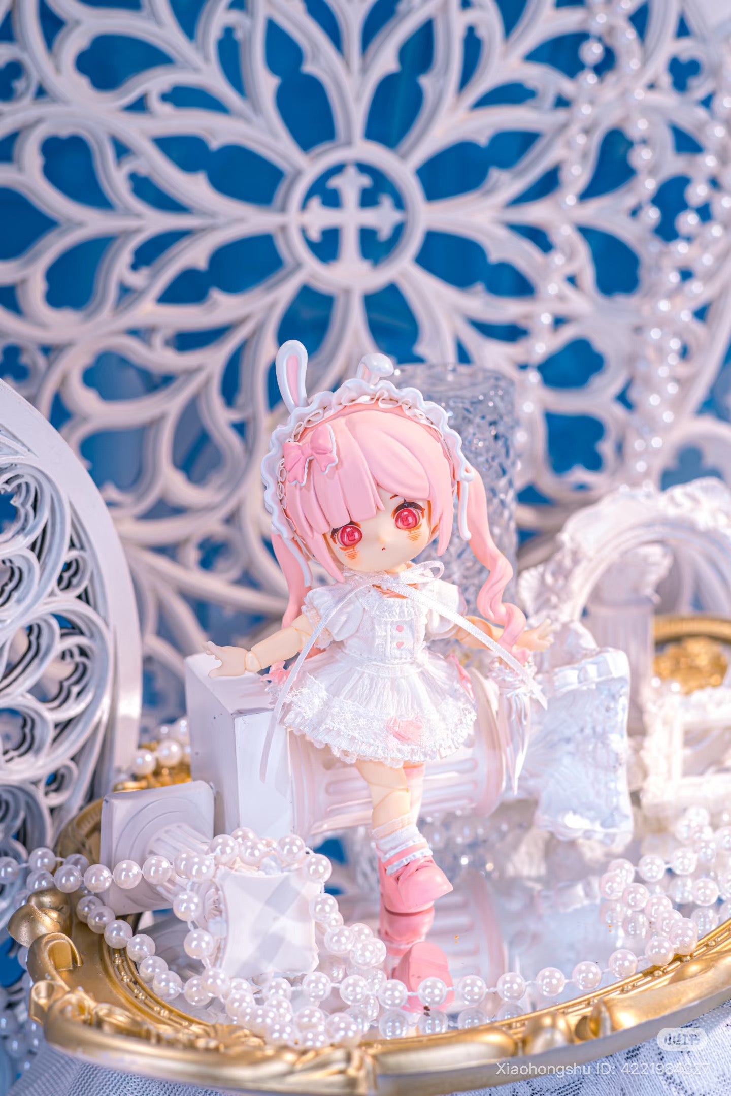 NAGI: The Phantom Record Series Articulated Figure, chibi-style with pink hair, in a Lolita dress, displayed on a decorative tray with pearls.