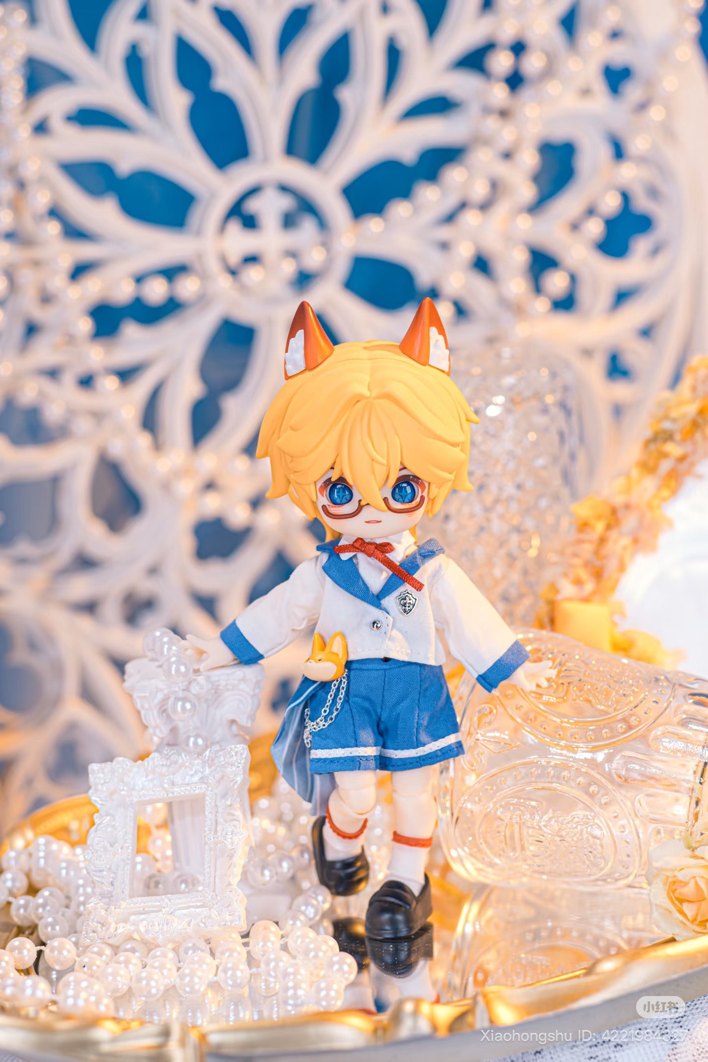 NAGI: The Phantom Record Series Articulated Figure with yellow hair, fox-ear accessories, and school uniform, displayed amid decorative pearls and ornate frames. Preorder for November 2025.