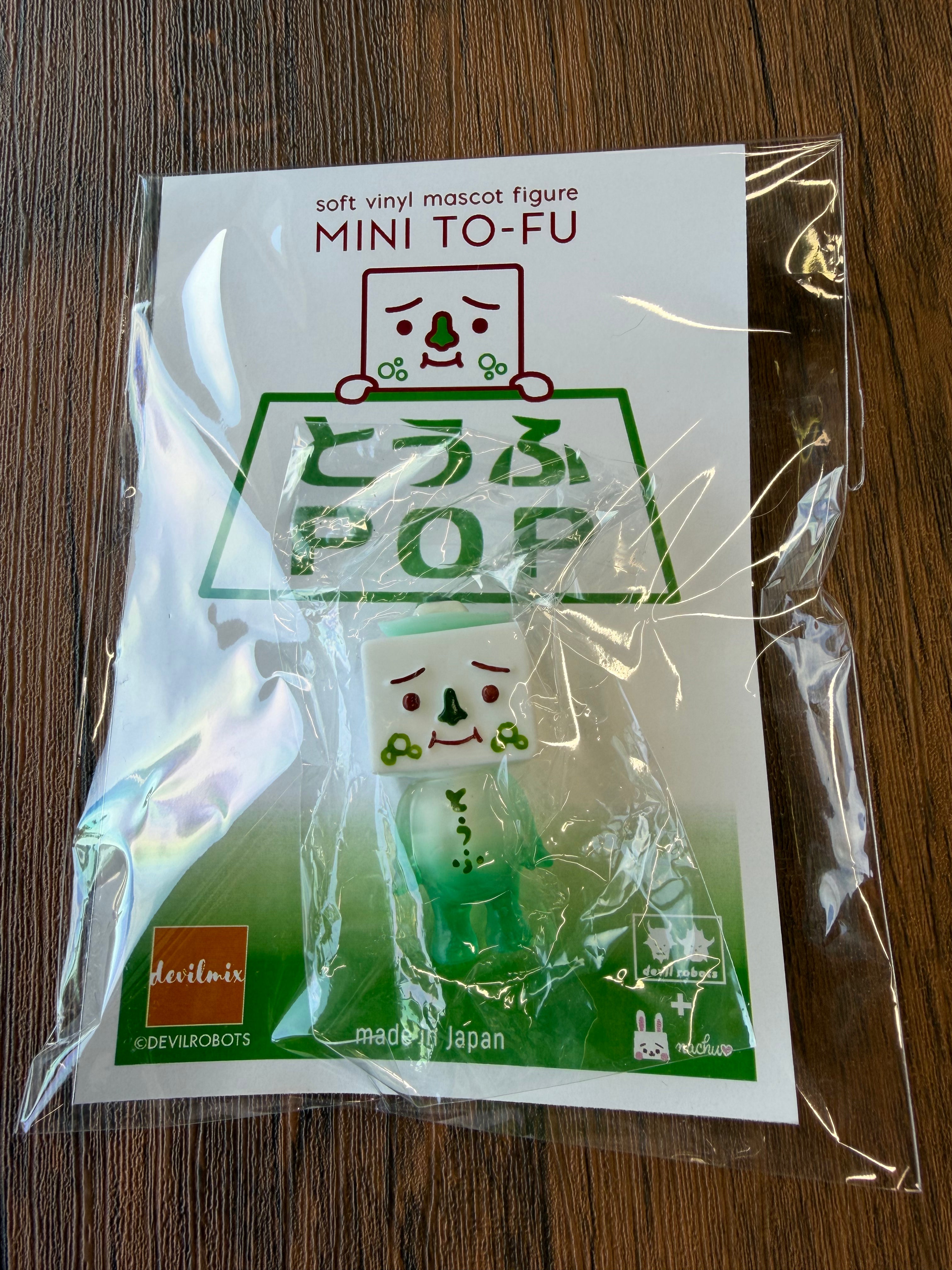 Mini To-fu - Otofu Pop by Devil Robots, a 5cm sofubi toy, features a smiling tofu block with pea-like cheeks, packaged with made in Japan branding.