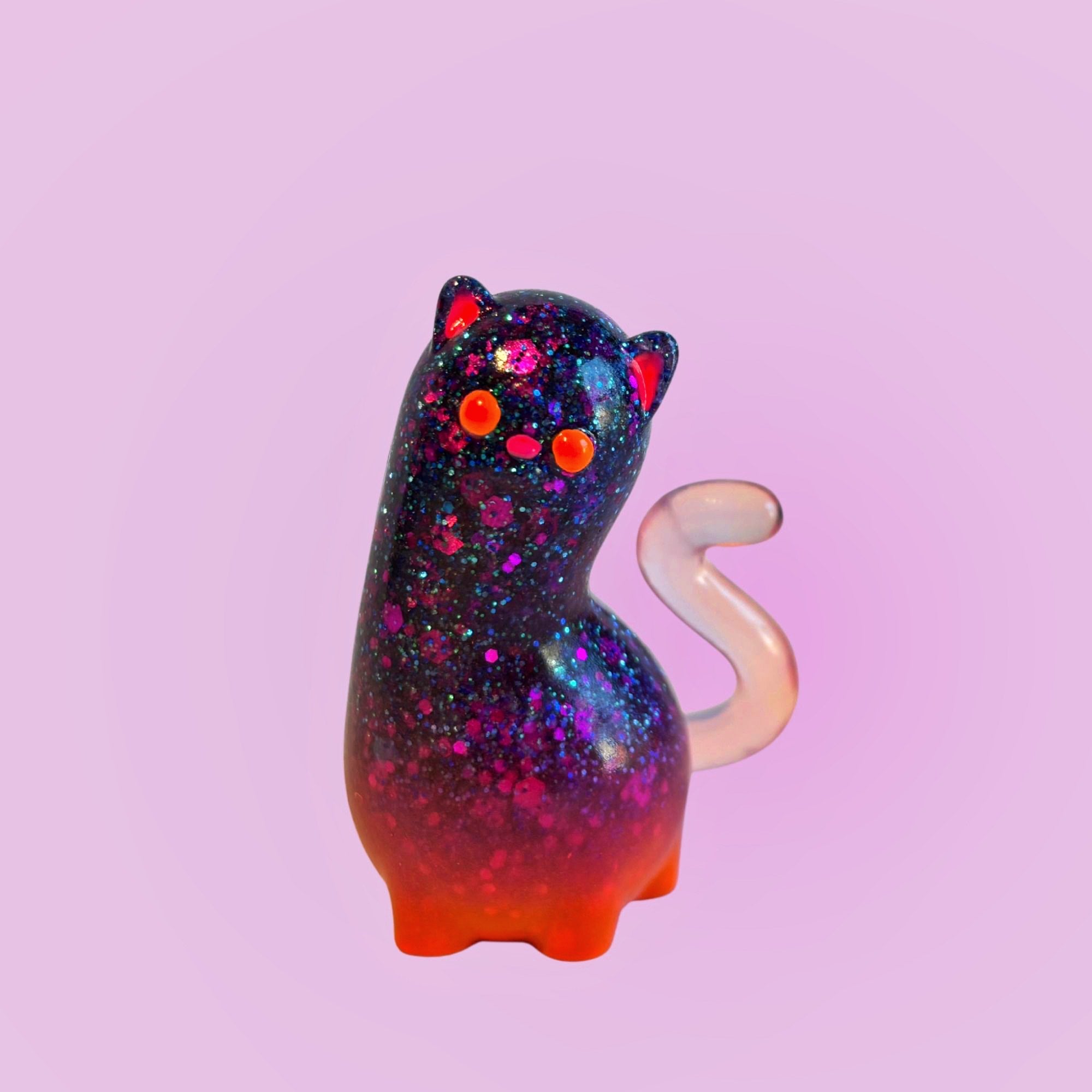 Spencer by Ghost Fox Toys: A small, glitter-filled resin cat figurine with a gradient body and opalescent tail, embodying vibrant artistry.