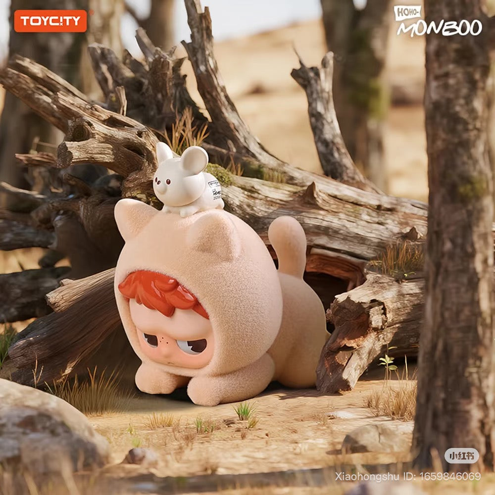 Vinyl figure MONBOO-Guardian Of The Homeland Series with red-haired kid in a cat-suit, mouse companion, set against logs; ToyCity logo visible.