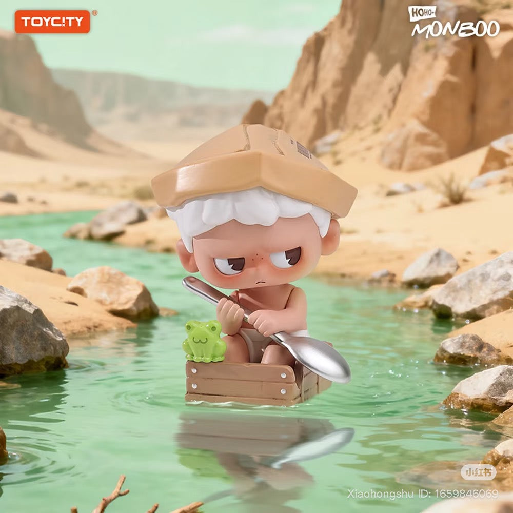 MONBOO-Guardian Of The Homeland Series Blind Box figurine: white-haired boy with cardboard hat, spoon paddle, and frog in crate-boat on desert stream.