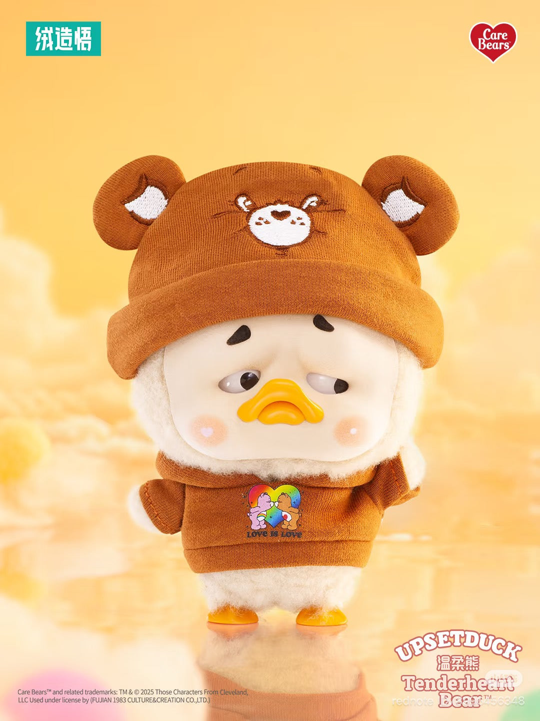 Care Bears x Upset Duck Be Rainbow Duck plush keychain in Care Bears outfit, featuring a knit beanie, hoodie with rainbow-heart motif, pre-order available.