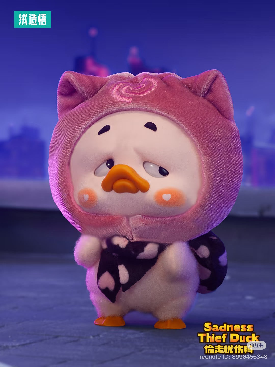 Plush keychain of a duckling in a pink cat-ear hood and heart-patterned scarf, titled Sadness Thief Duck, part of the Upset Duck Colorful Player series.