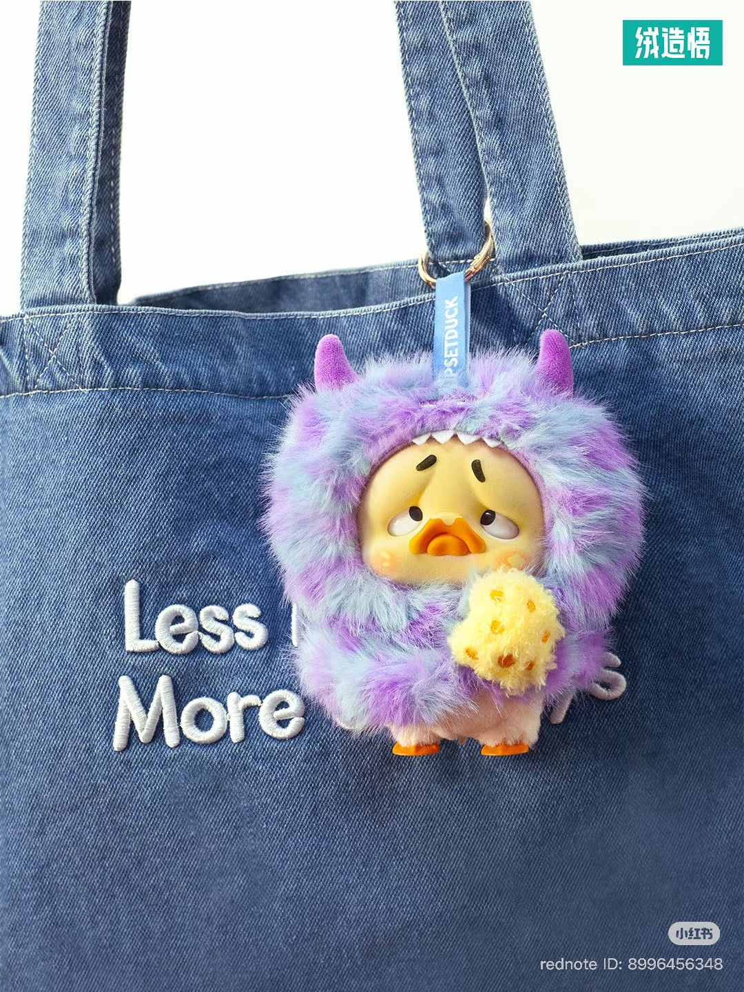 Denim tote with Less More embroidery, adorned with Upset Duck Colorful Player Duck Plush Keychain in a monster suit, available for preorder.