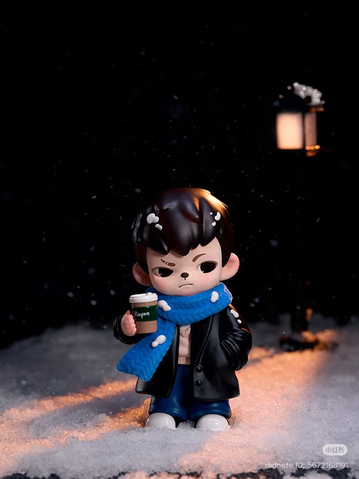 Rayan Let't Date Series figure in snowy scene, wearing a coat and scarf, holding a coffee cup, part of a blind box collection.