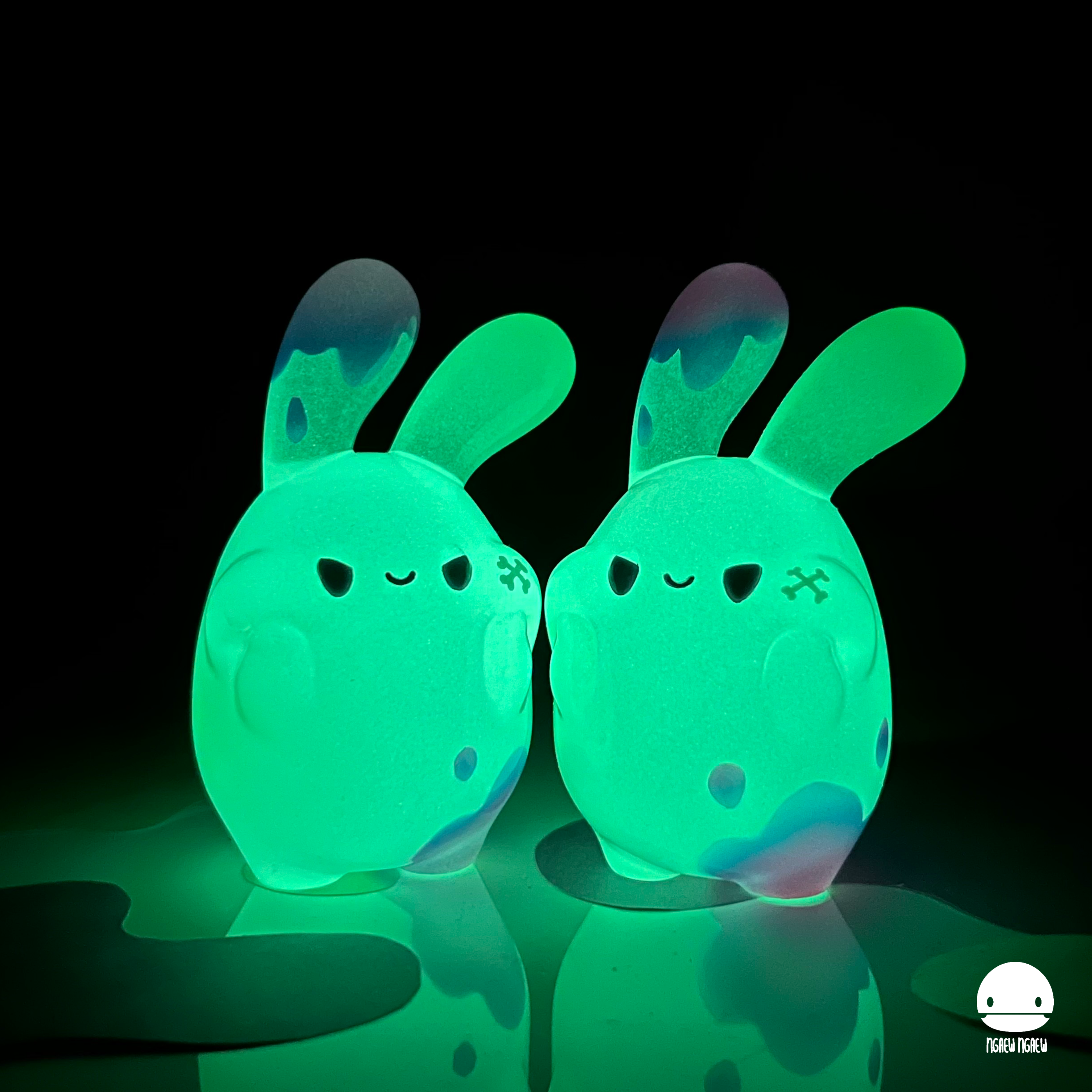 Ngaew ngaew Chubby Bubble(Poison) by Ngaew Ngaew, two glowing toy bunnies, green and purple object, and green balloon in the sky, limited edition preorder from Strangecat Toys.