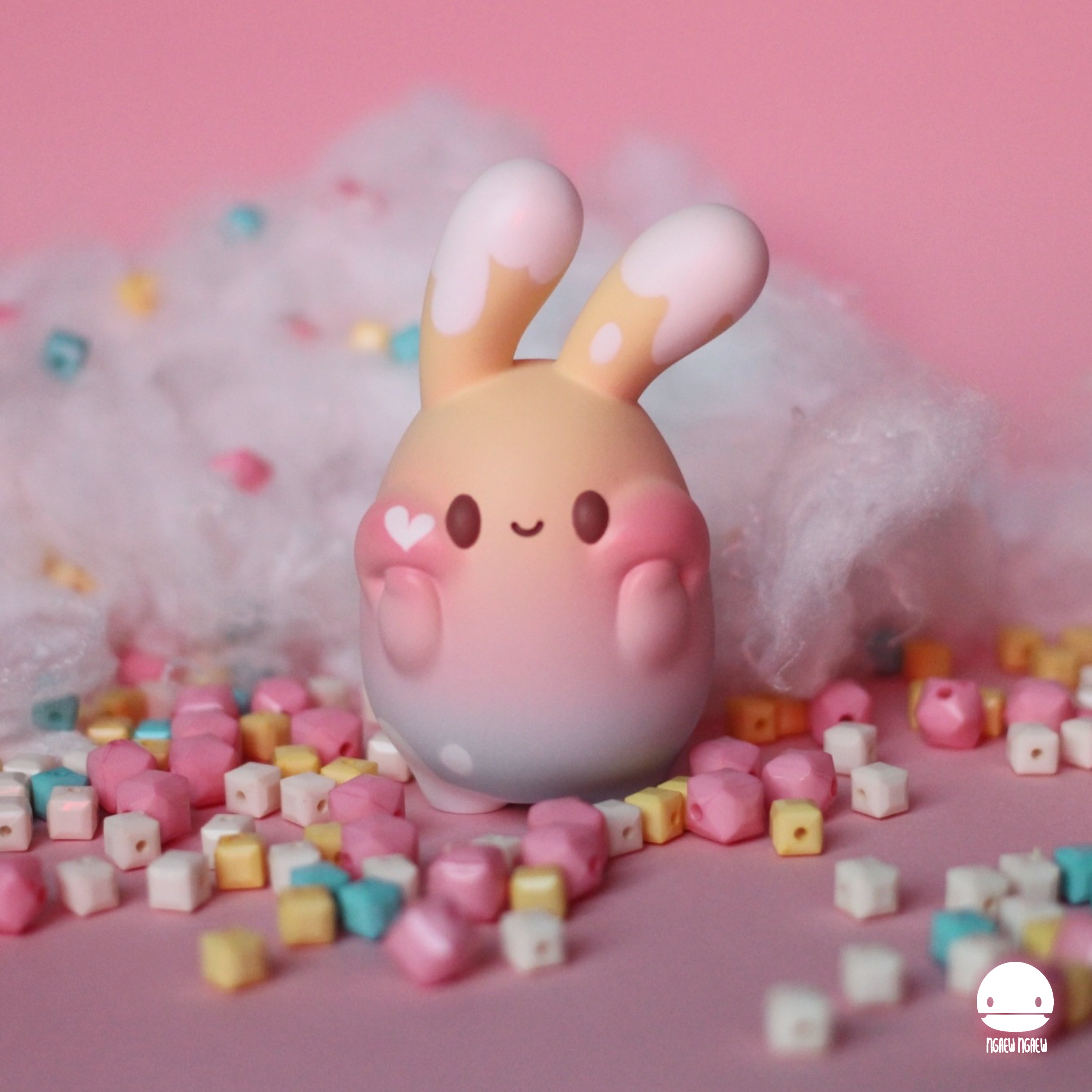 Toy bunny on beads, close-up of toy, cube, and pig. Limited edition Ngaew Ngaew Choco Rainbow, 8 cm resin figure.