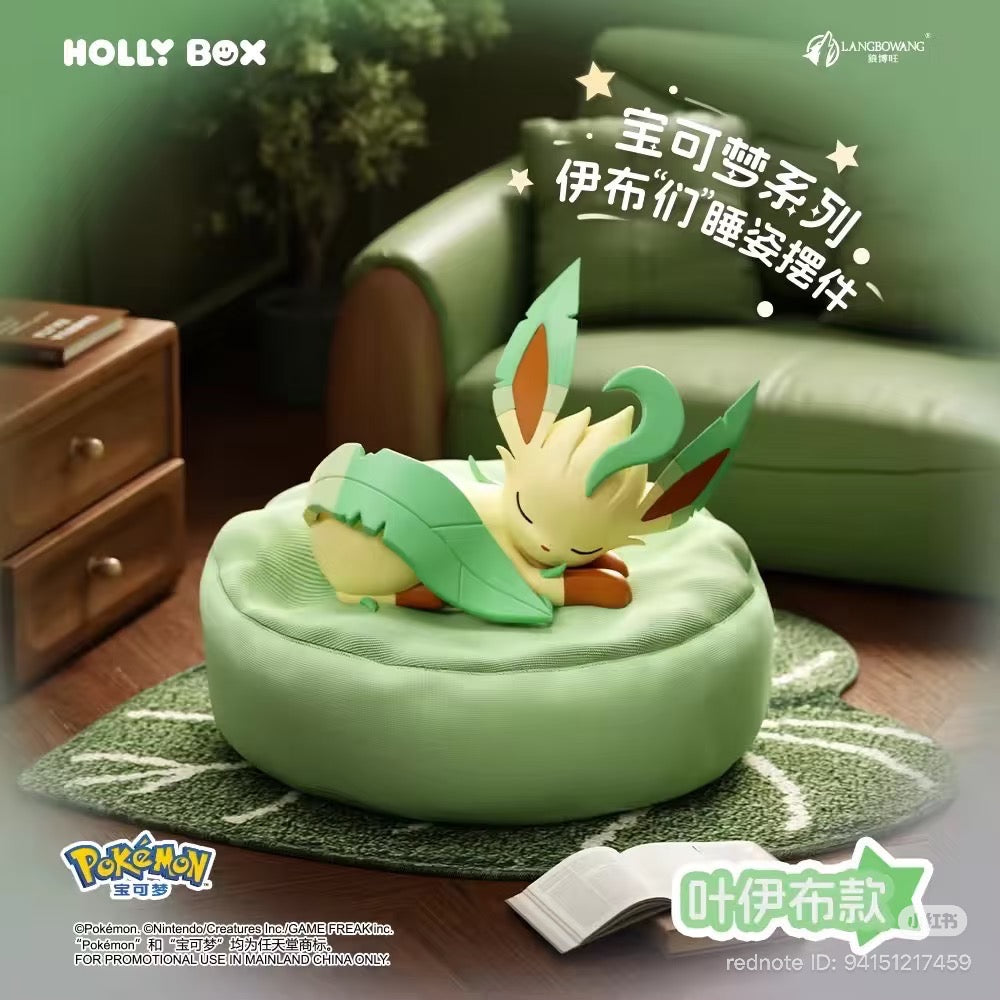 Leafeon figure from Pokémon Eeveelutions Sleeping Pose Series, curled on a cushion bed in a cozy living room setup, featuring HOLLY BOX branding.