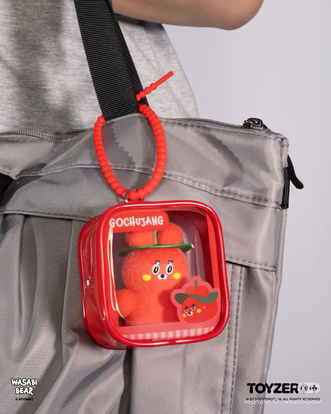Wasabi Bear Outing Pals Series Blind Box featuring a red PVC zipper pouch with a fuzzy mascot inside, hanging from a bag strap.