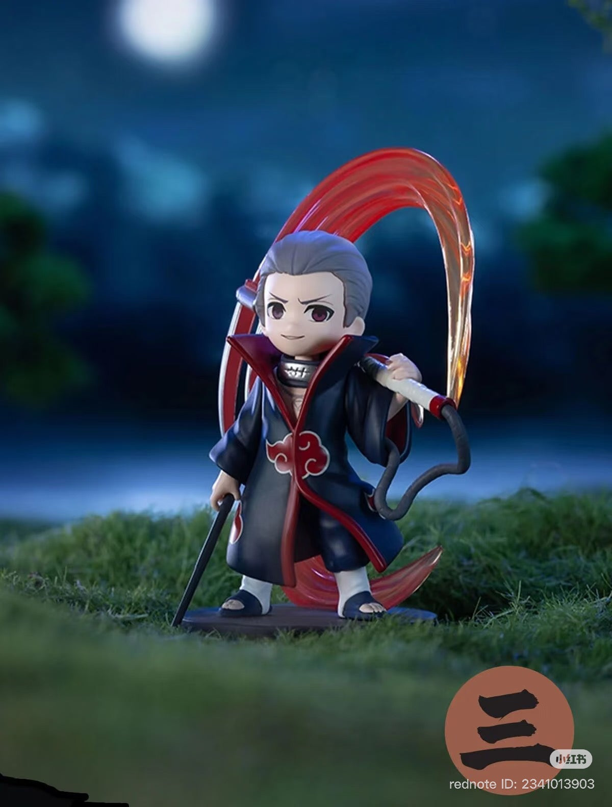 Chibi Hidan figure from Naruto: Shippuden Series, posed with scythe and ritual energy, on a grassy base. Preorder for Q4 2025 shipment.