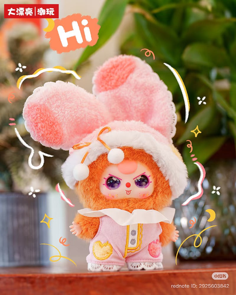 Baby Three - Sweet Dreams Plush Blind Box: a bright orange plush toy with purple eyes, pink overalls, and a bunny-ear hood, featuring playful doodles and Chinese text.