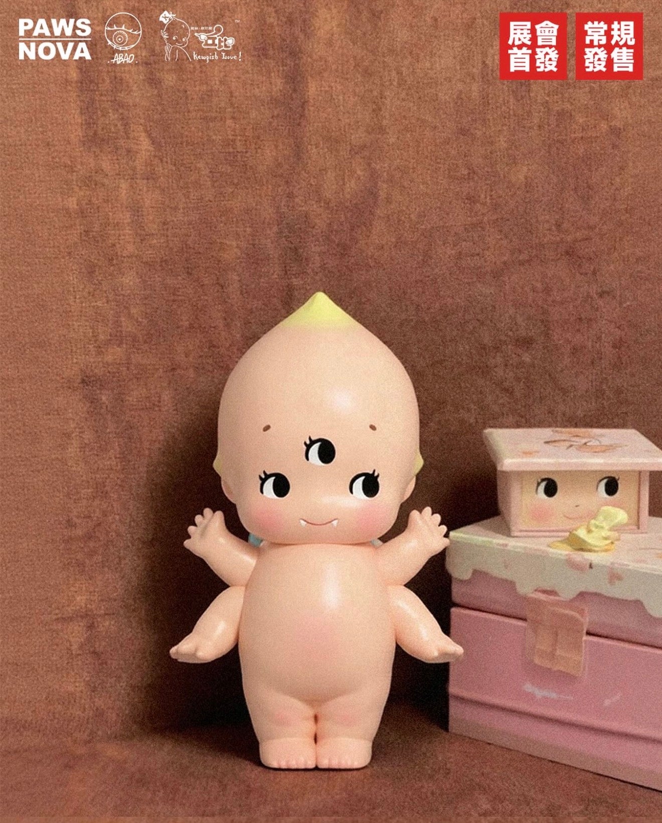 ABAO × Kewpish Love Mini - Preorder features a unique four-armed Kewpie-style vinyl baby toy with a third eye, alongside a pink face-adorned box.