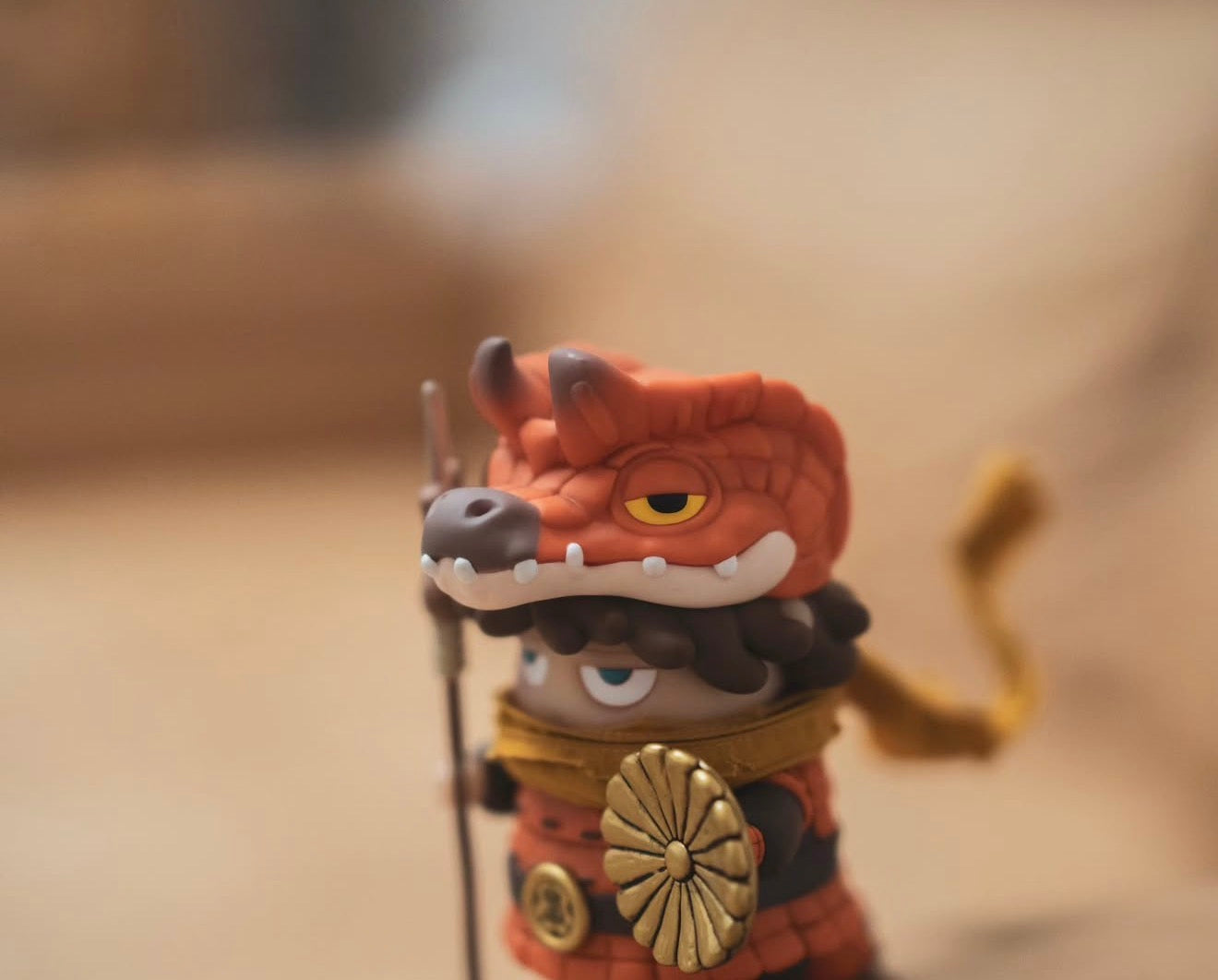 Poh x Booker Warrior vinyl art toy in samurai armor, dragon-head helmet, holding a spear, featuring a golden chrysanthemum emblem. Preorder now, shipping Jan 2026.