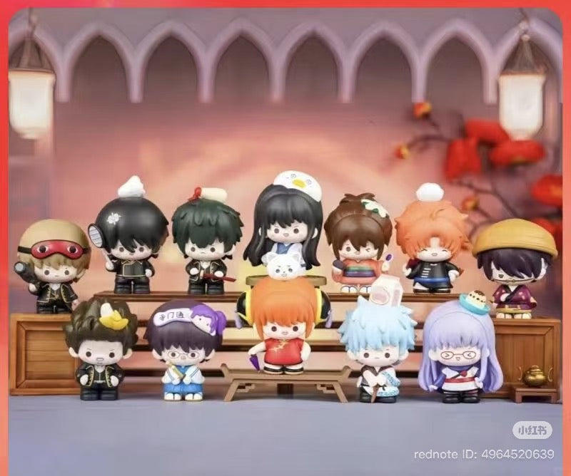 Gintama Moe Series Vol.1 Blind Box figurines displayed on wooden steps, featuring 12 chibi characters with food-themed hats.