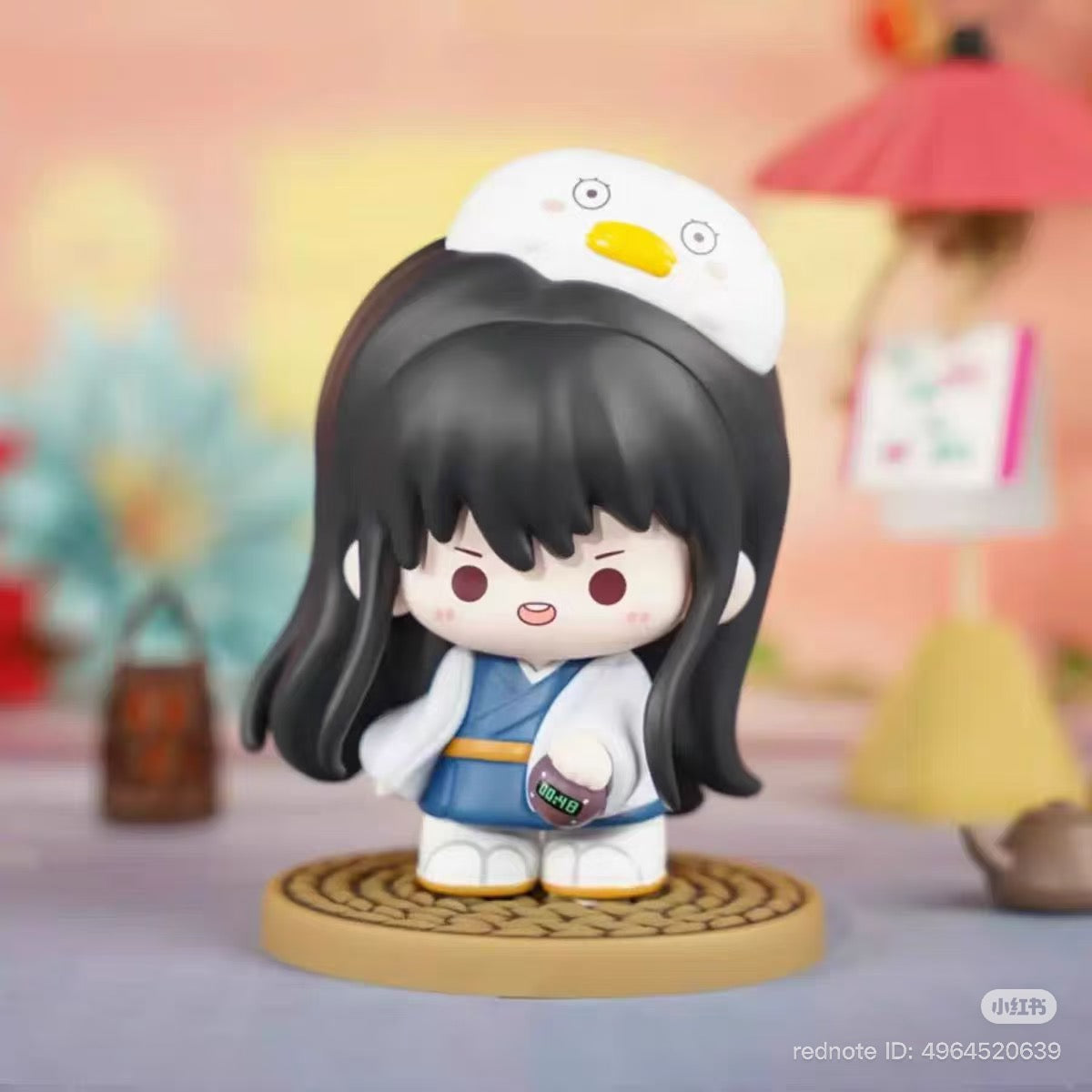 Chibi figurine from Gintama Moe Series Vol.1 Blind Box, featuring a girl with a chick hat and digital timer, standing on a woven mat.