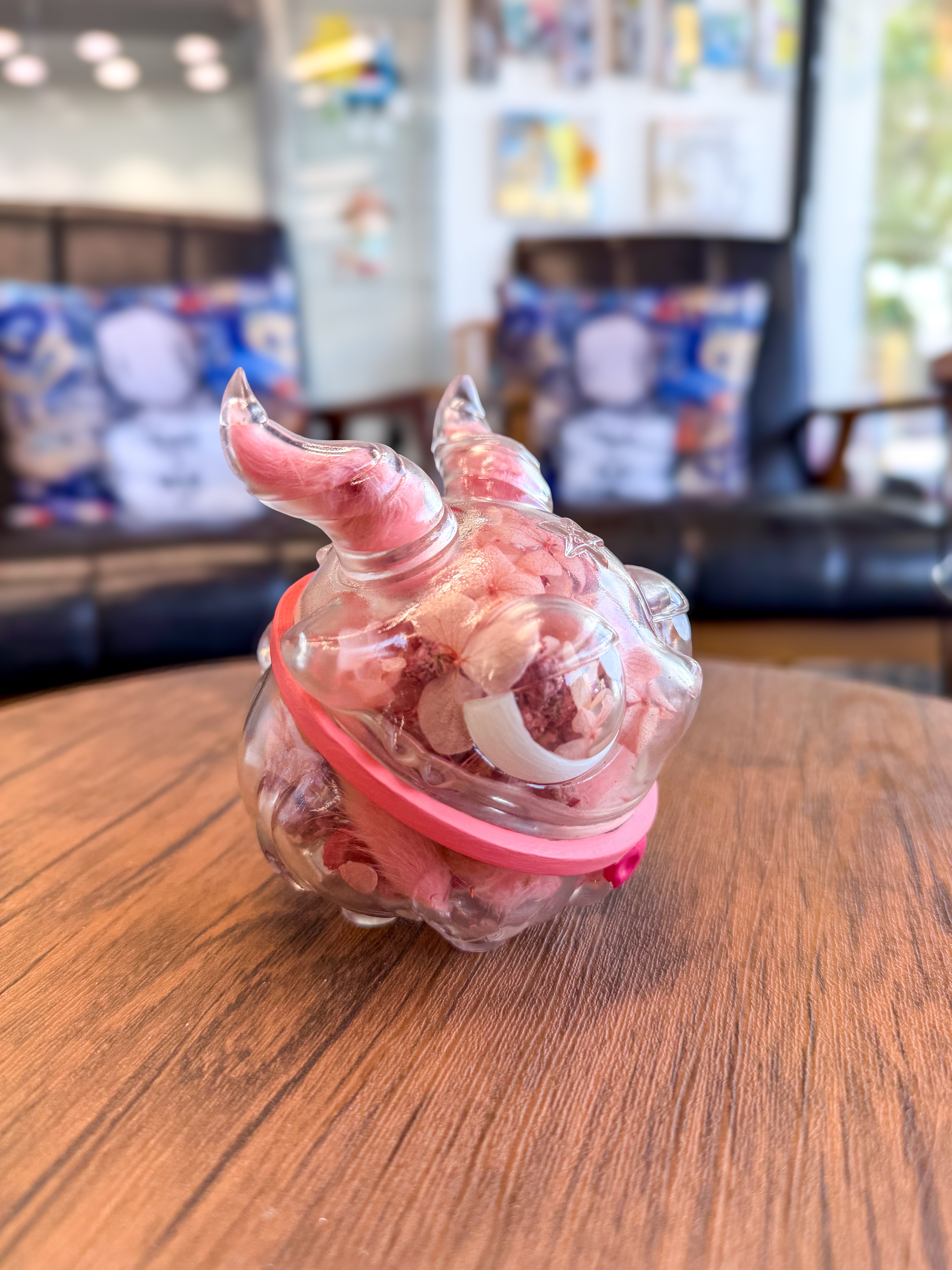 Sweet on the inside Bobbi by Zintears: A 10cm vinyl orb resembling a horned creature's head, filled with pink shredded material, sealed with a pink silicone ring.