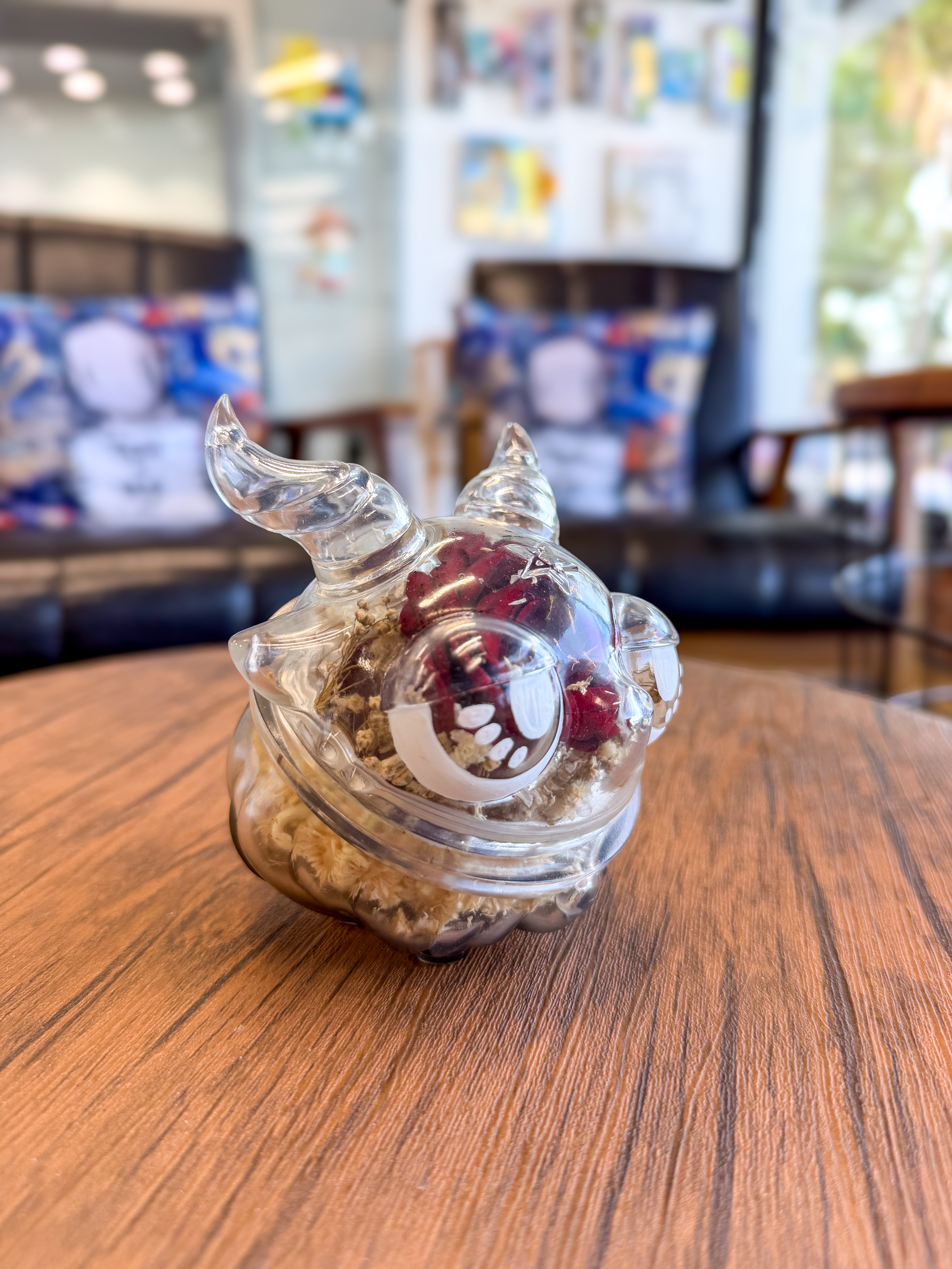 Sweet on the inside Bobbi by Zintears: A 10cm vinyl jar, horned creature shape, filled with dried botanicals, displayed on a wooden tabletop.