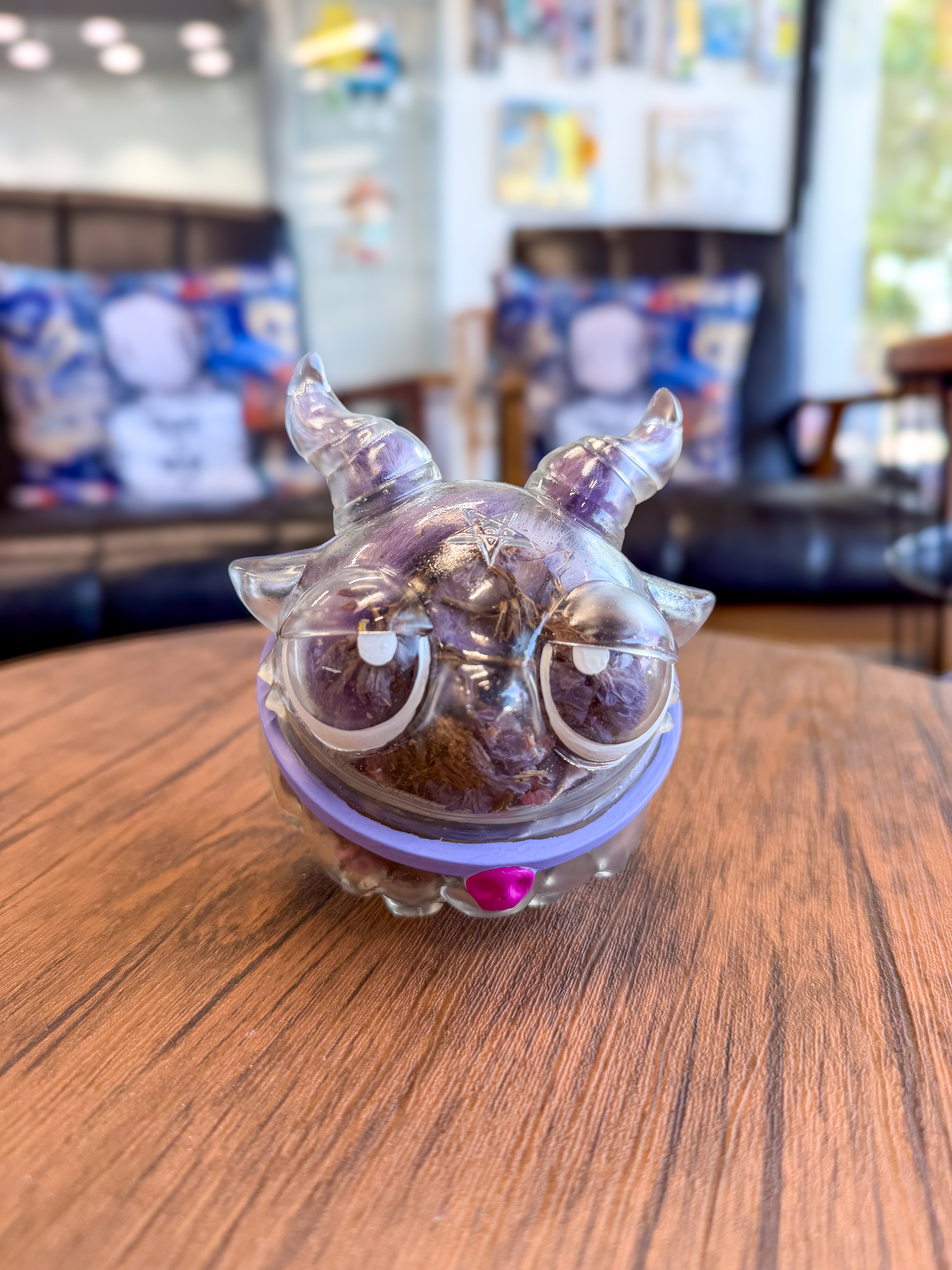 Sweet on the inside Bobbi by Zintears, a 10cm vinyl figurine, features a transparent shell filled with dried botanicals, horned creature design, and pink heart accent.