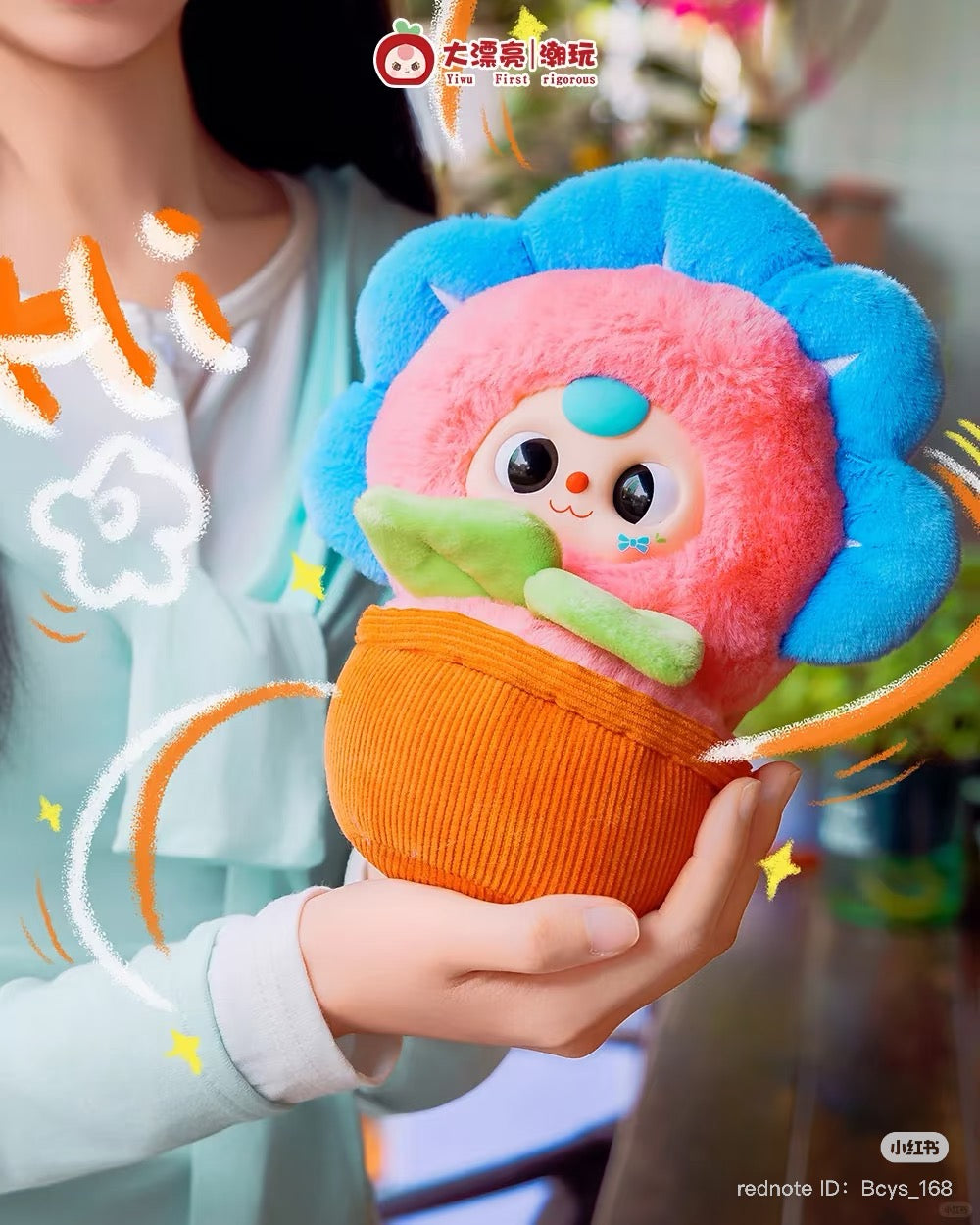 Close-up of Baby Three Flower Pot Plush Keychain Blind Box, featuring a cartoonish stuffed animal face, available for preorder. Ships estimated late July 2025.