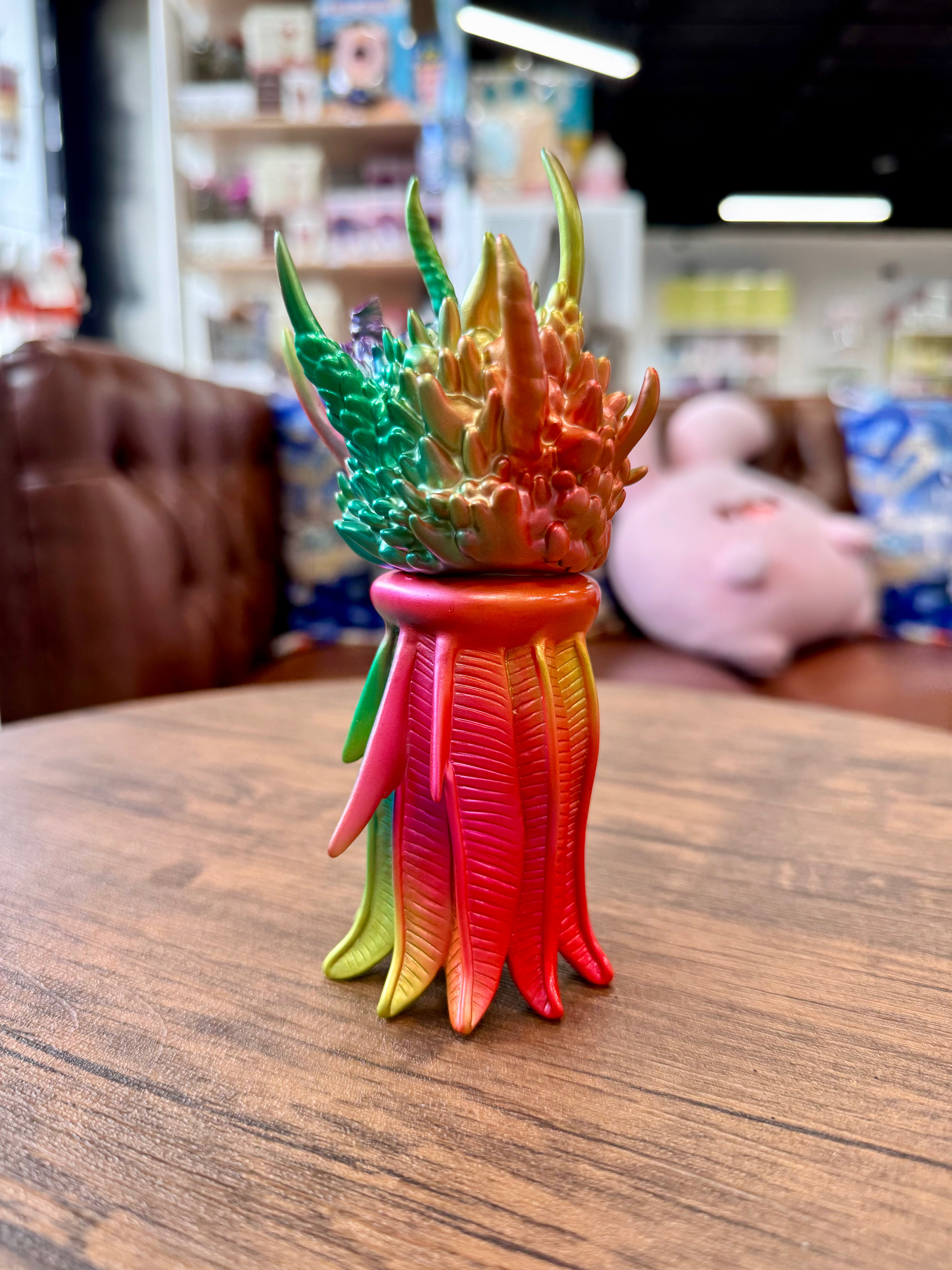 Genie Metal Gradation by YASU, a Japanese Sofubi toy, sits prominently on an indoor floor, embodying Strangecat Toys' unique art toy collection.