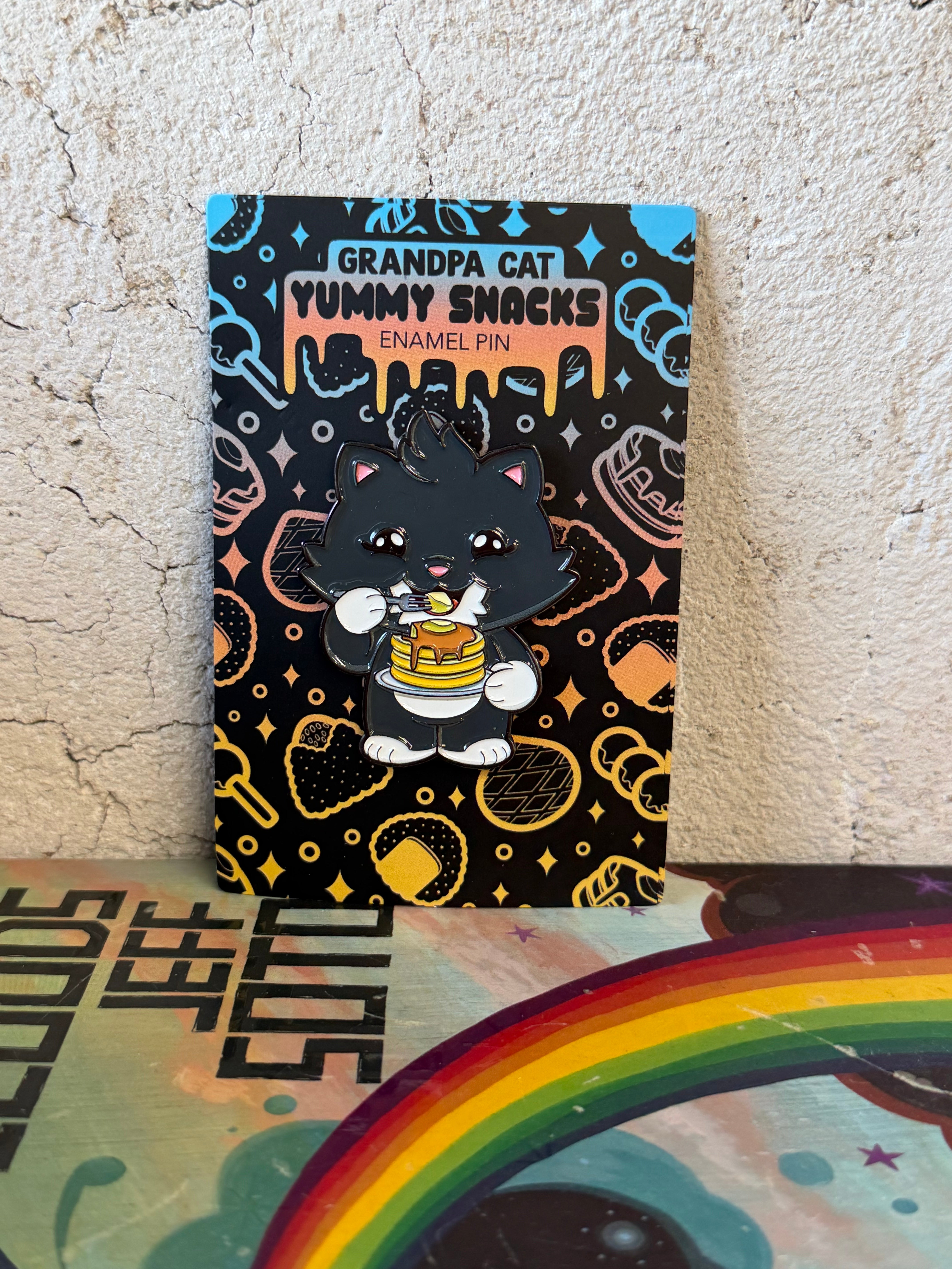 Grandpa Pin - Japanese Snack Series: Chibi black cat with fork and pancakes, displayed on a themed card with snack icons, by Strangecat Toys.