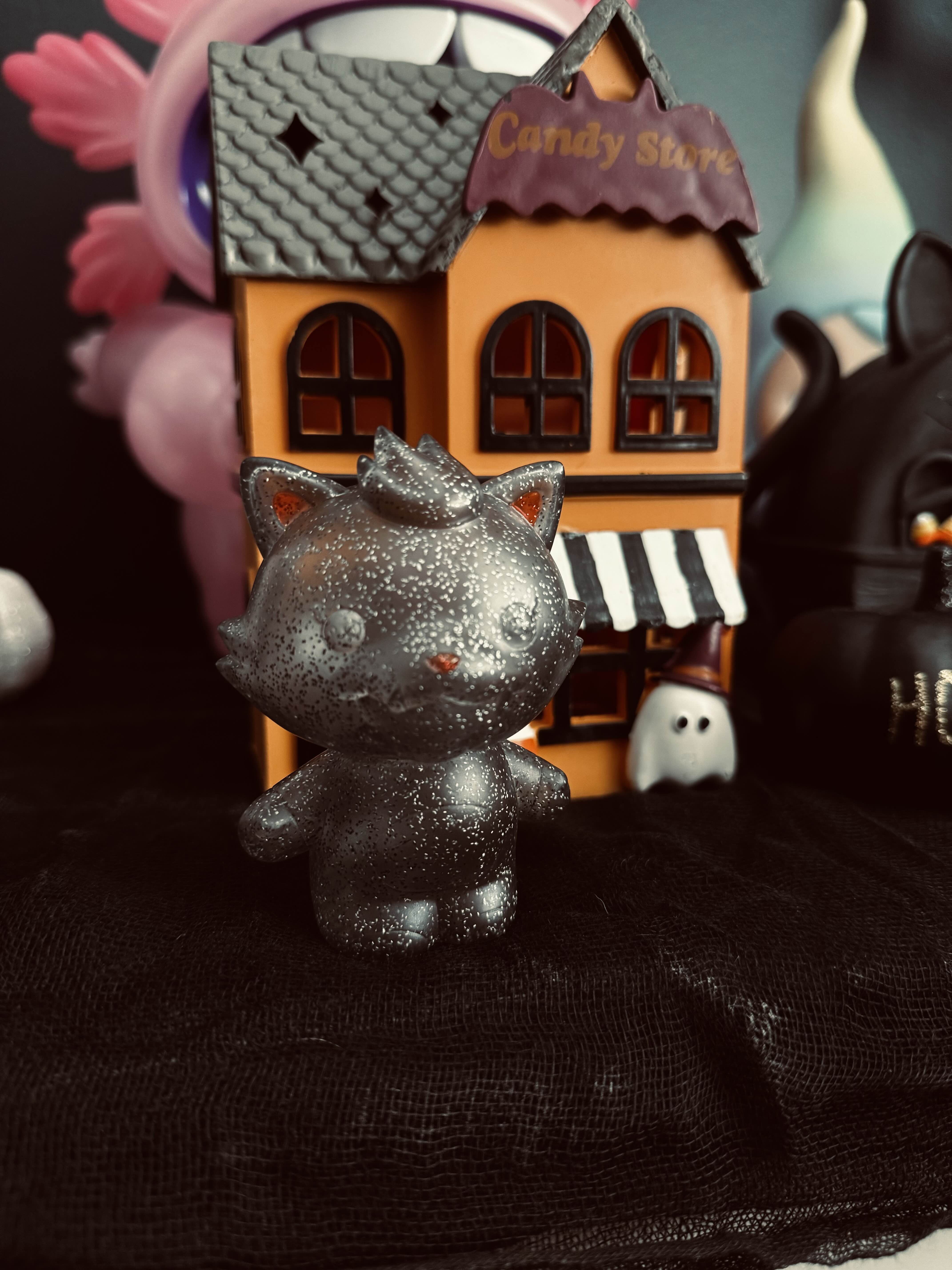 Grandpa Sofubi - Ghost of Grandpa Glitter Edition, a 10cm sculpted toy cat, stands beside a small house, limited edition of four by P.P.PUDDING.