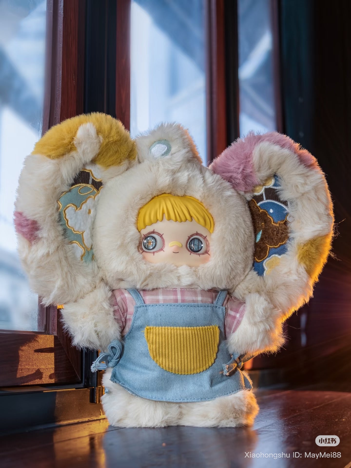 Maymei 400% Forgotten Funfair Plush Keychain Blind Box: A stylized doll in a fluffy animal suit with oversized ears, wearing a pink shirt and denim overalls.
