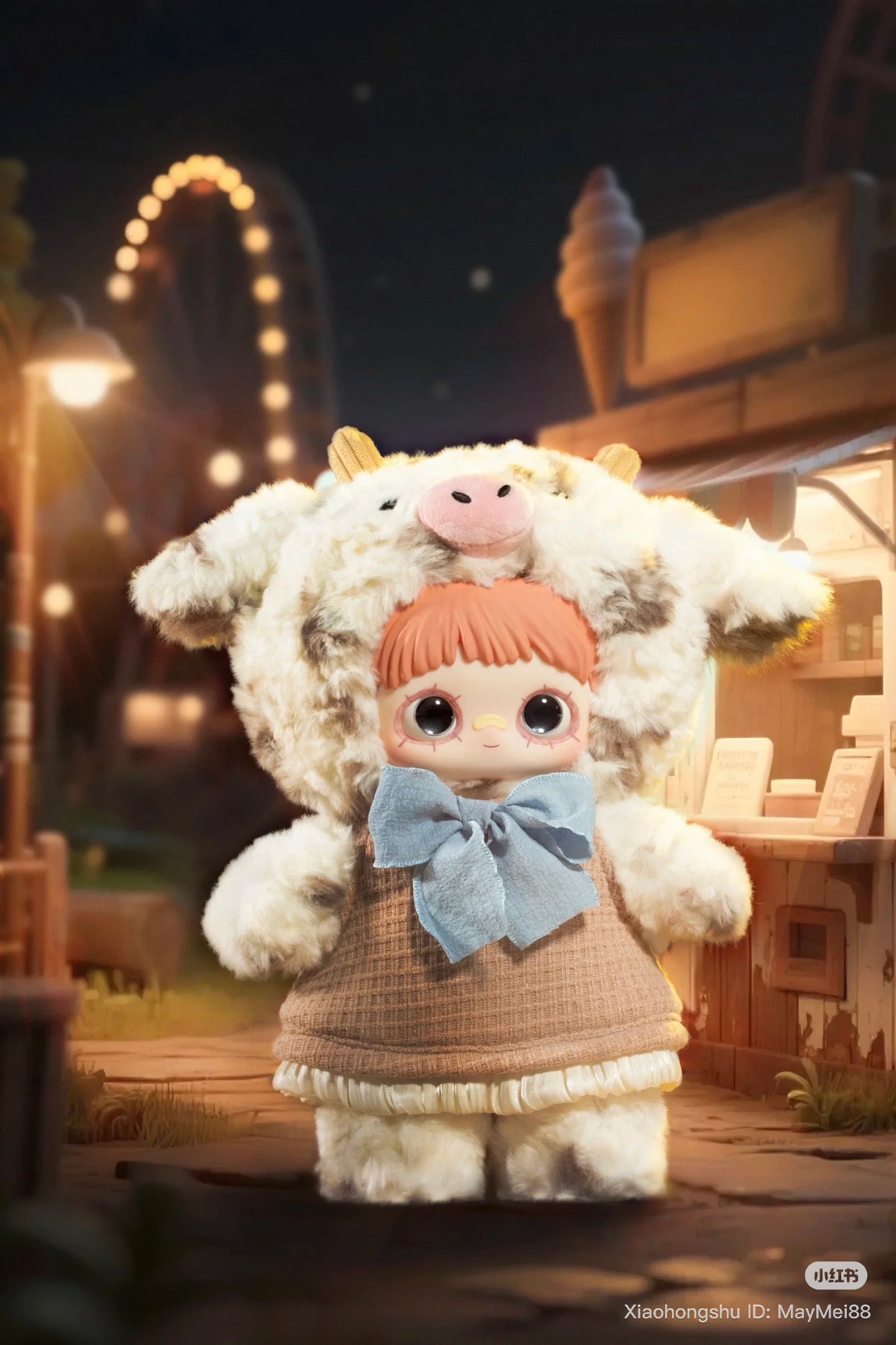 Maymei 400% Forgotten Funfair Plush Keychain Blind Box features a doll in a cow costume with a blue bow, set against a nighttime fair backdrop.